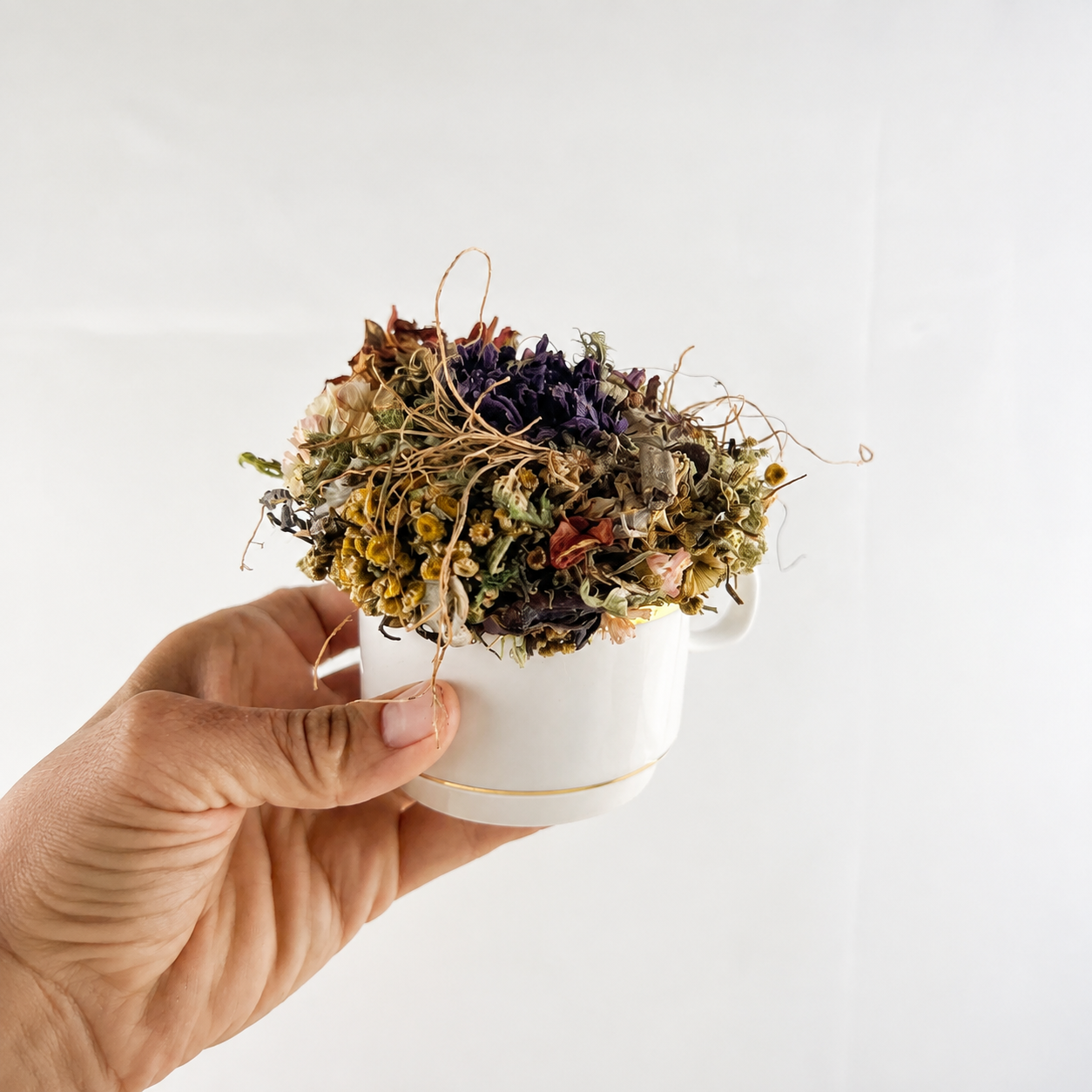 One-of-a-kind teacup dried flower arrangement with burgundy, rust and natural woodland textures.