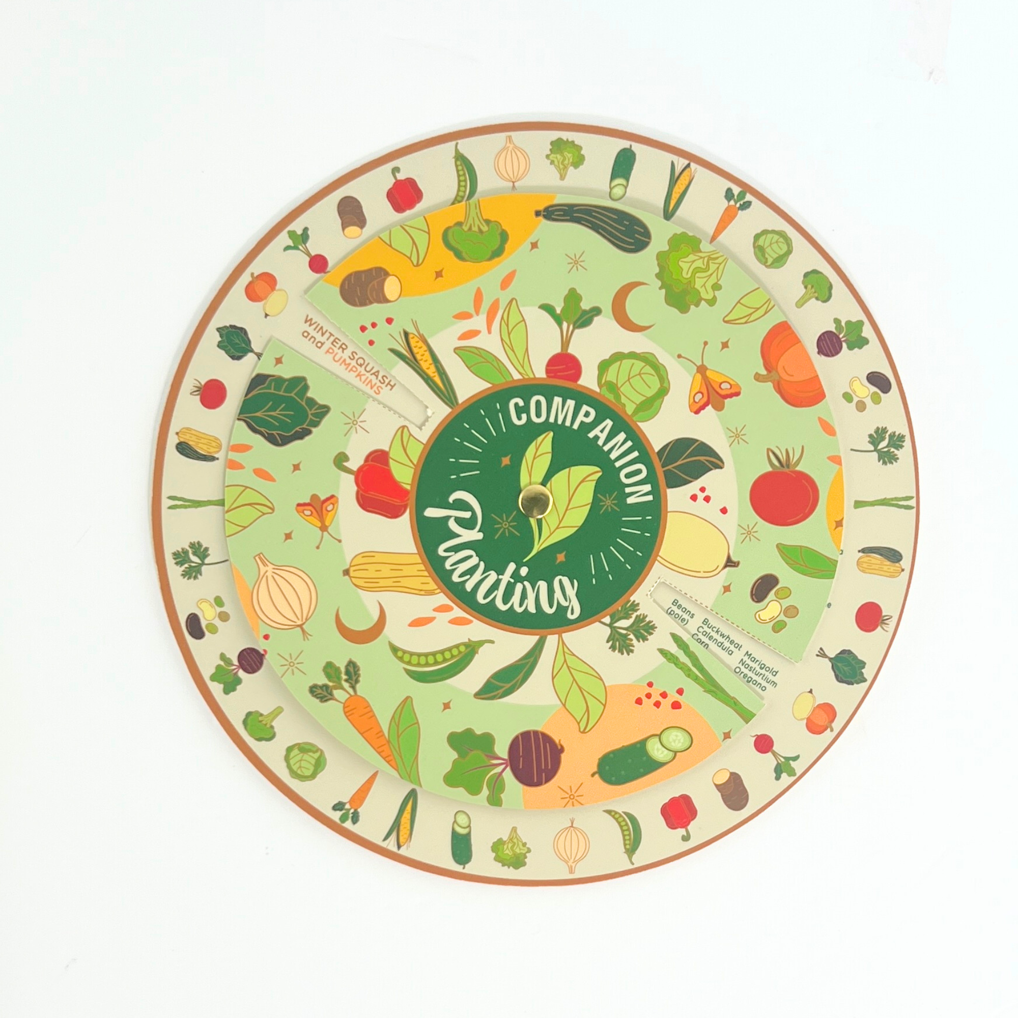 Circular companion planting wheel and matching illustrated booklet for vegetable garden planning and plant compatibility.