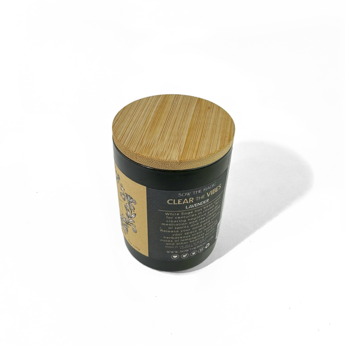 Angled view of the Clear the Vibes Lavender candle with its bamboo lid and gold botanical label