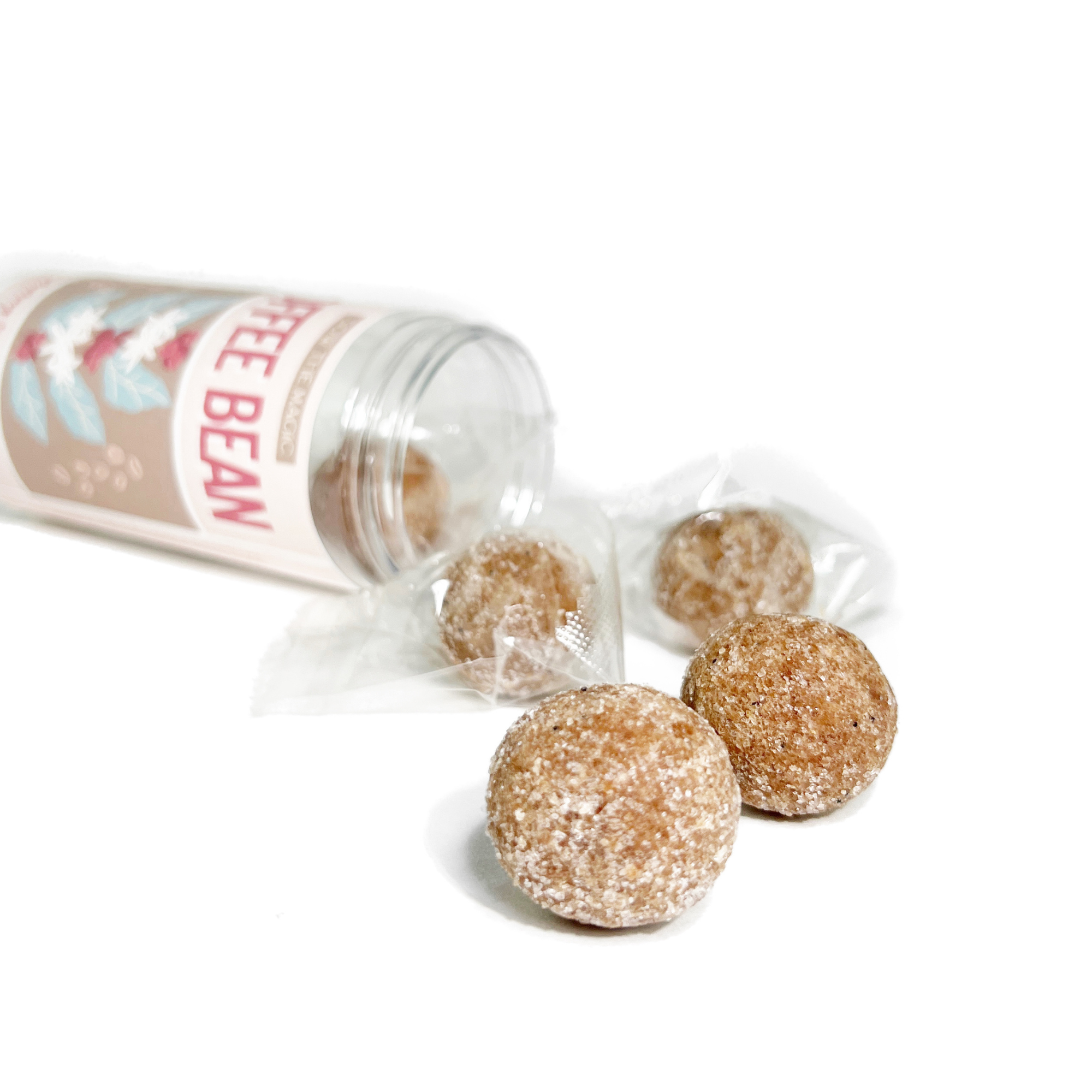 Flat lay of Coffee Bean Exfoliating Sugar Scrubs poured from a reusable jar with individually wrapped exfoliating scrub cubes.