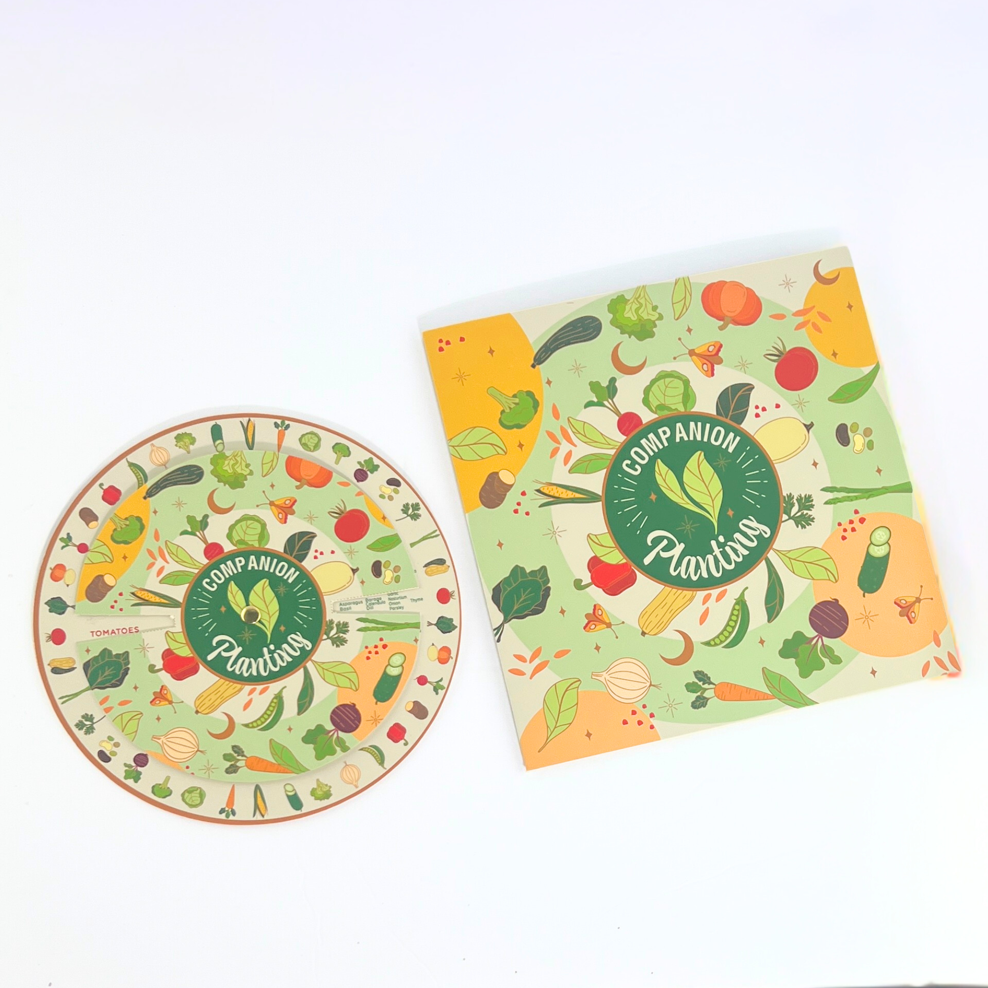 Companion planting wheel and booklet showing illustrated vegetables like tomatoes, carrots, cucumbers, and leafy greens for gardening tips.