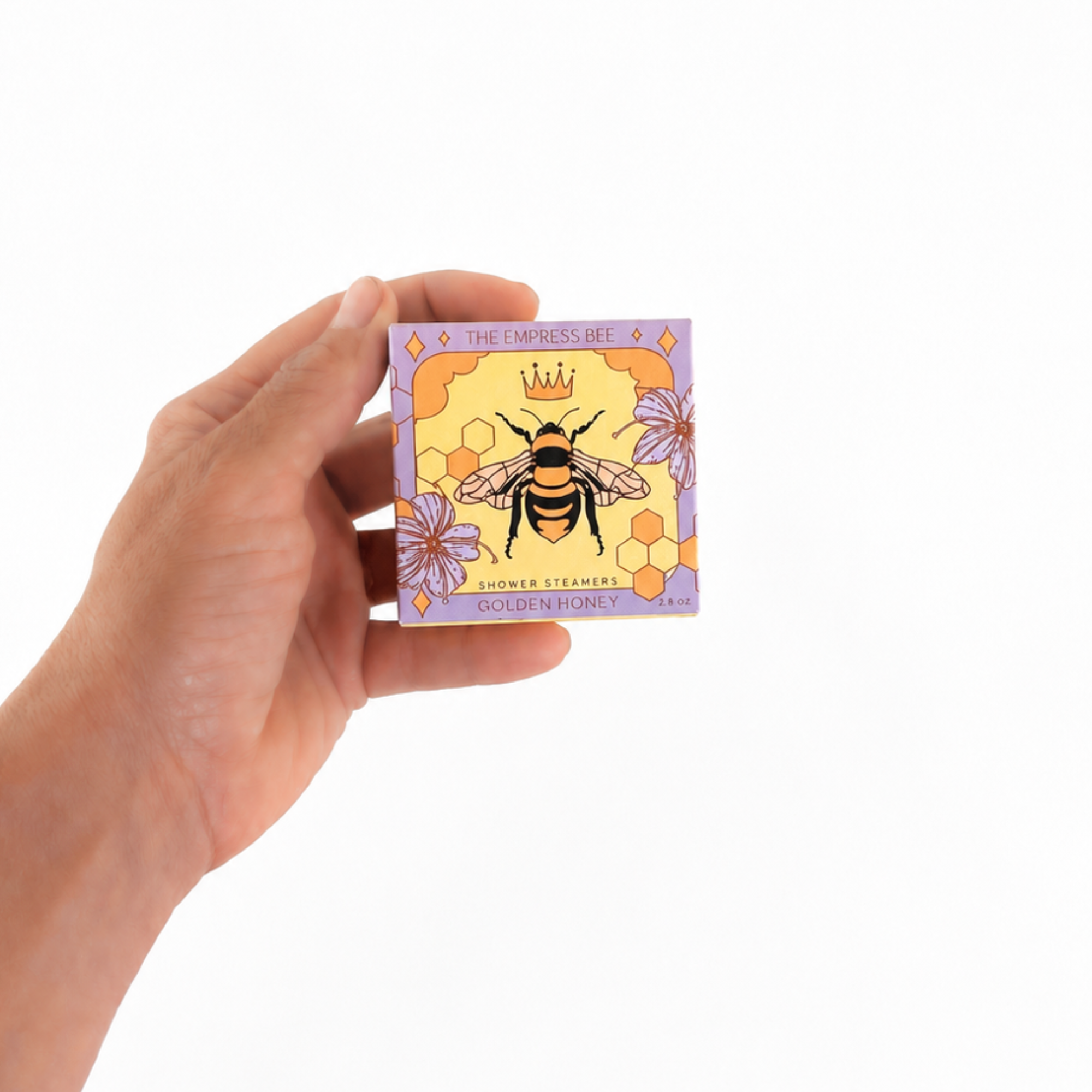 Hand holding The Empress Bee Shower Steamer Set in Golden Honey by Sow the Magic® to show the size of the botanical aromatherapy gift set.