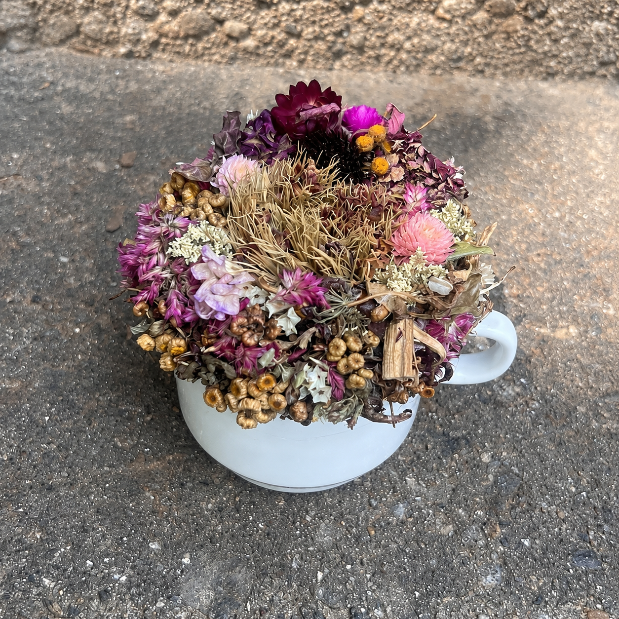 Handmade February birth month dried flower arrangement featuring pink, burgundy and cream botanicals in a vintage teacup