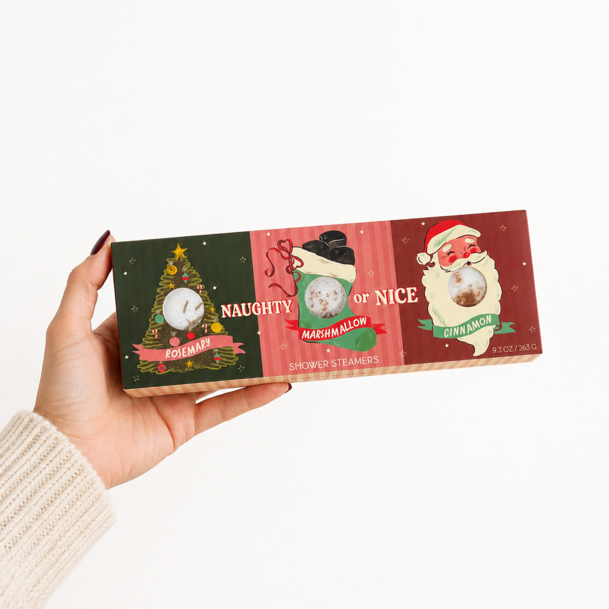 Hand holding the Sow the Magic Naughty or Nice Christmas Shower Steamers gift box against a clean white background for holiday gift presentation.