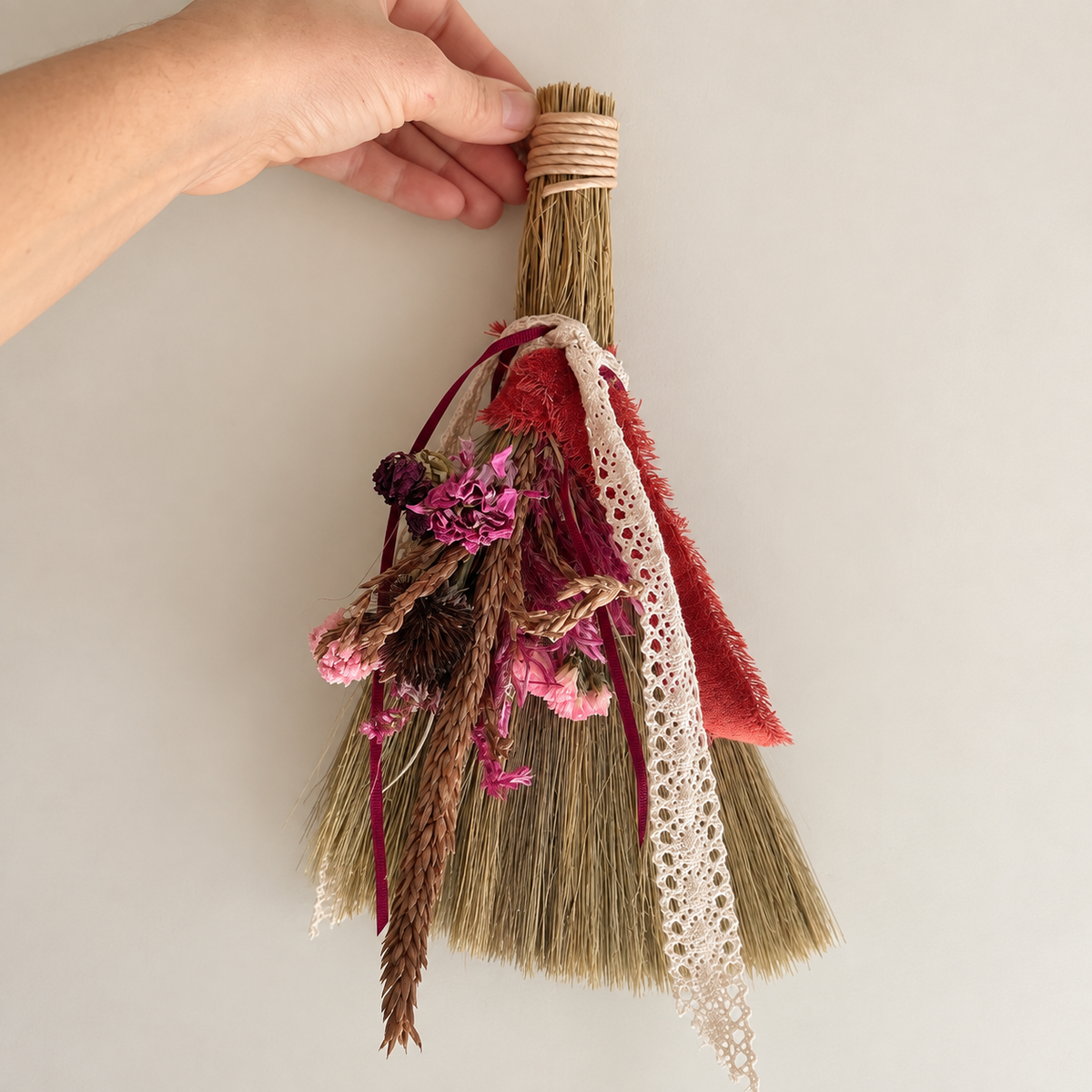 Front view of a handmade botanical broom displayed beside a 12-inch ruler to show its approximate size.