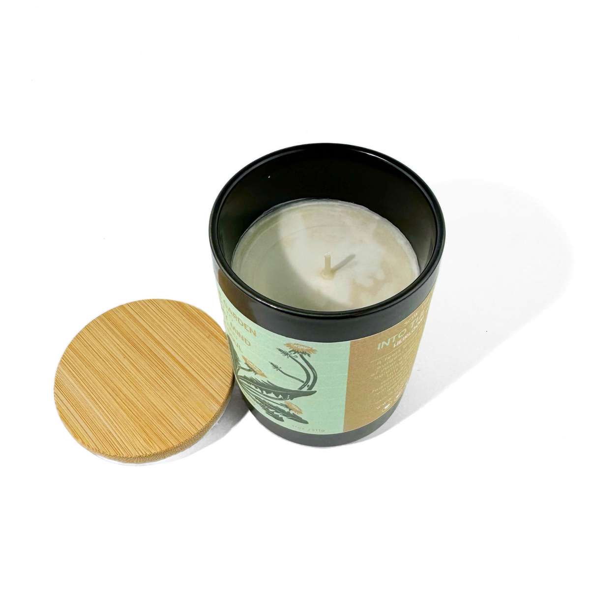 Open Into the Garden Heirloom Tomato candle showing ivory wax and cotton wick with bamboo lid beside it
