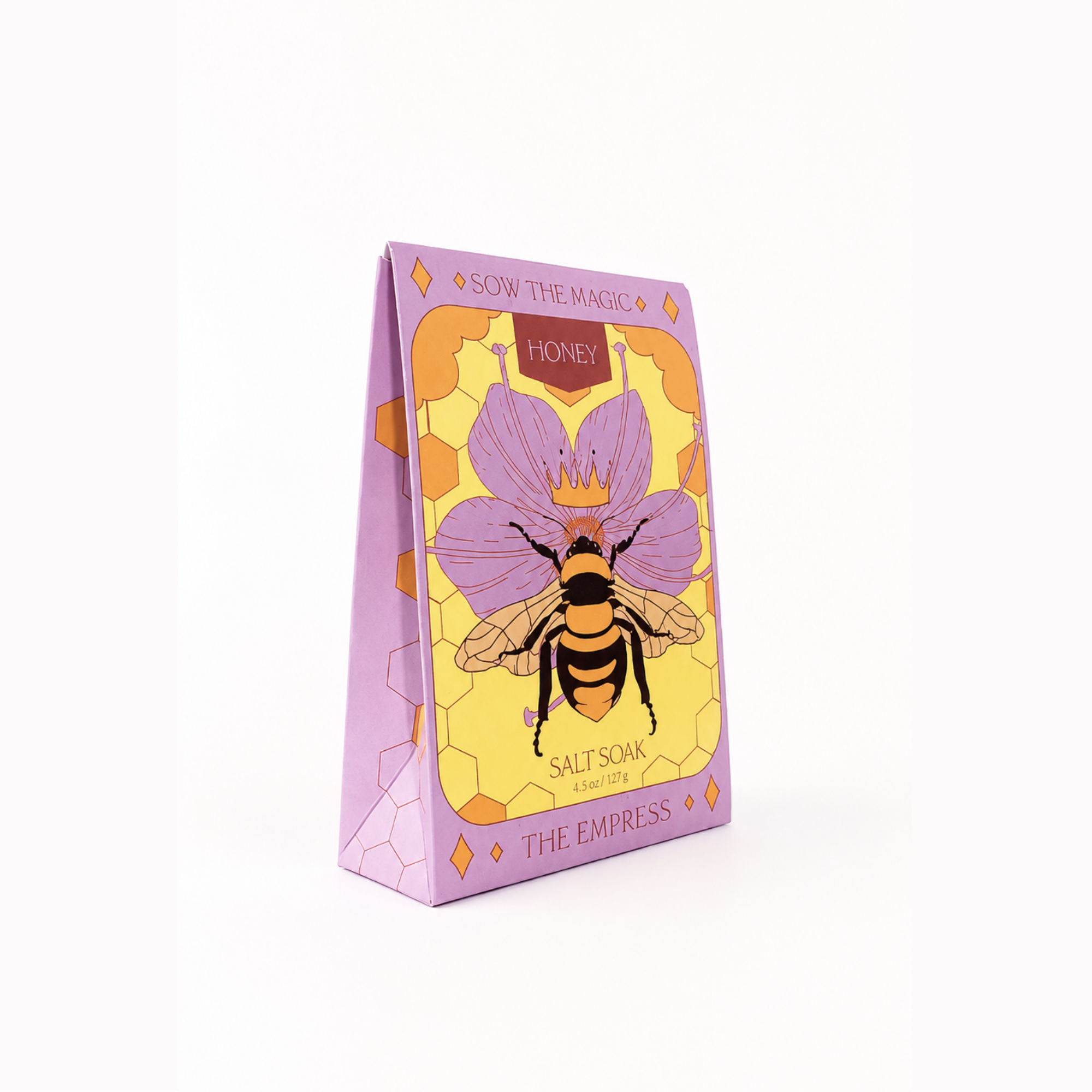 Angled view of Sow the Magic® Honey Salt Soak – The Empress botanical bath salts featuring Himalayan pink salt and Epsom salt in illustrated gift box packaging with honeybee and floral artwork on a white background.