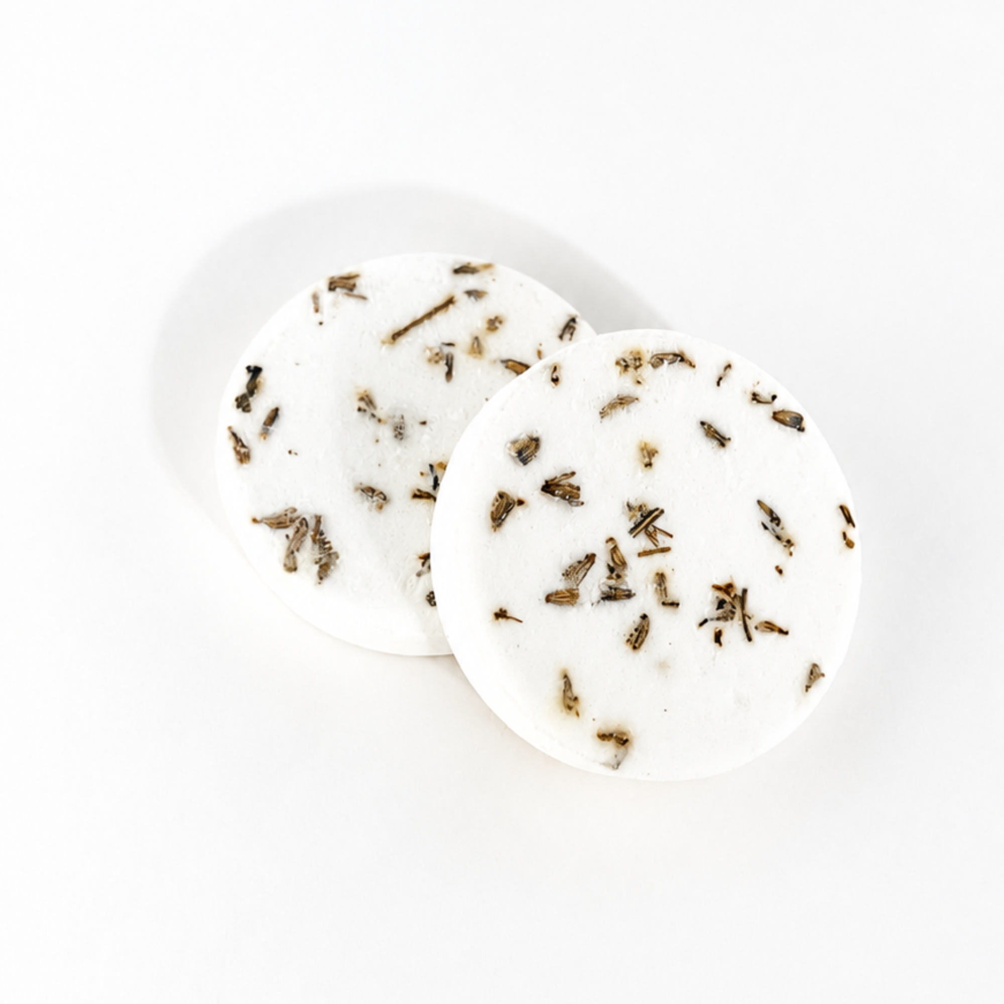 Two handcrafted Lavender Mint shower steamers decorated with dried lavender buds and botanicals on a white background.