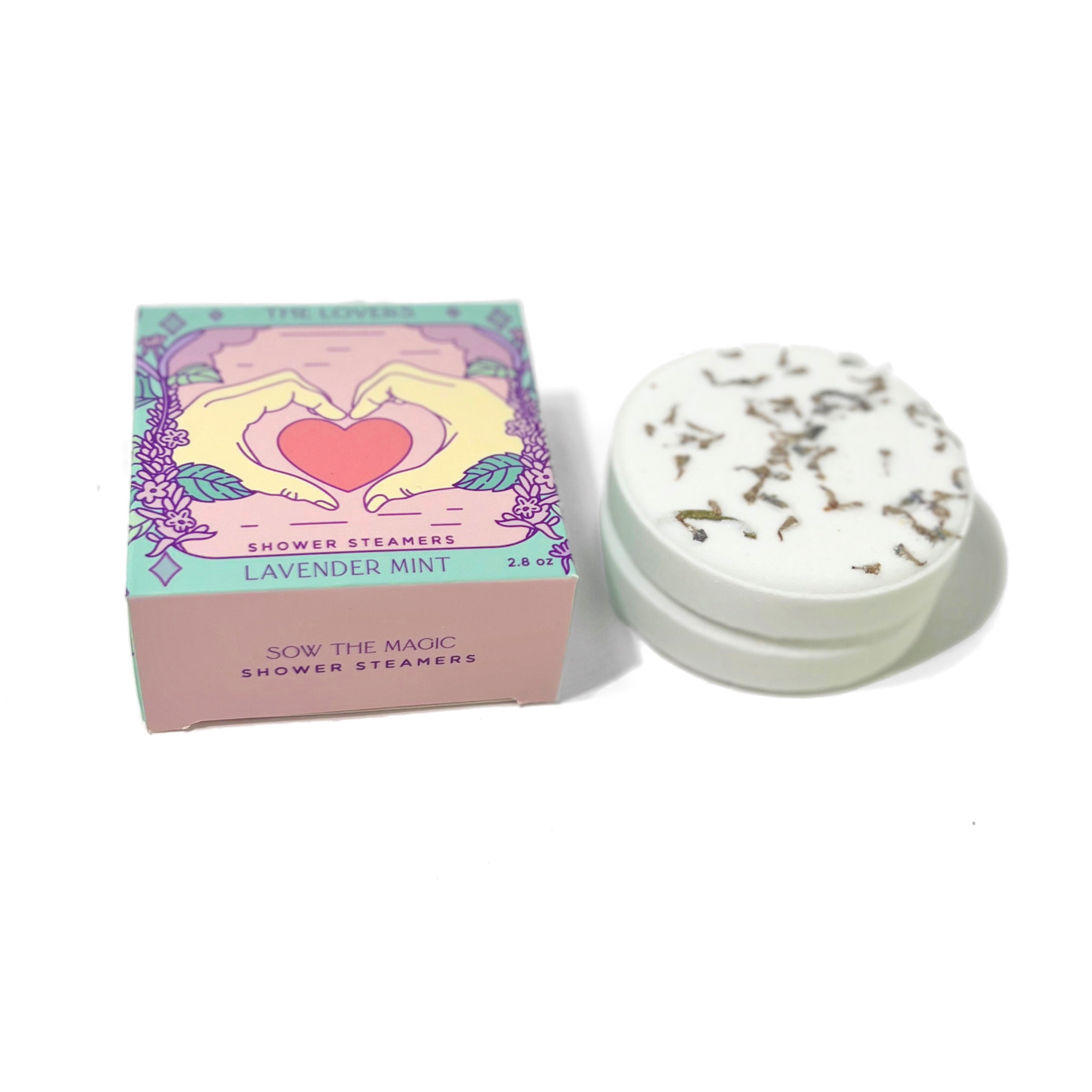 The Lovers Shower Steamer Set in Lavender Mint displayed beside a handcrafted botanical shower steamer.