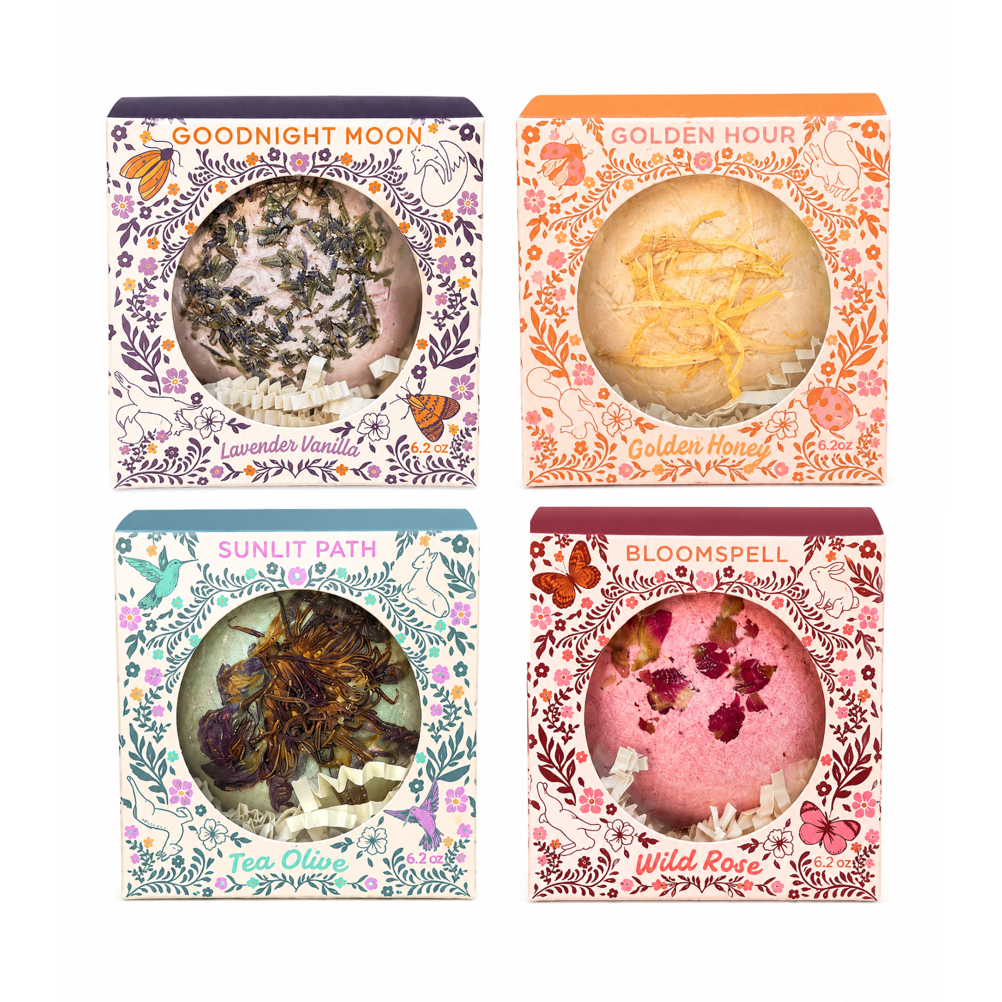 Collection of four handcrafted botanical bath bombs in whimsical storybook gift boxes featuring Bloomspell Wild Rose, Goodnight Moon Lavender Vanilla, Golden Hour Golden Honey and Sunlit Path Tea Olive by Sow the Magic.