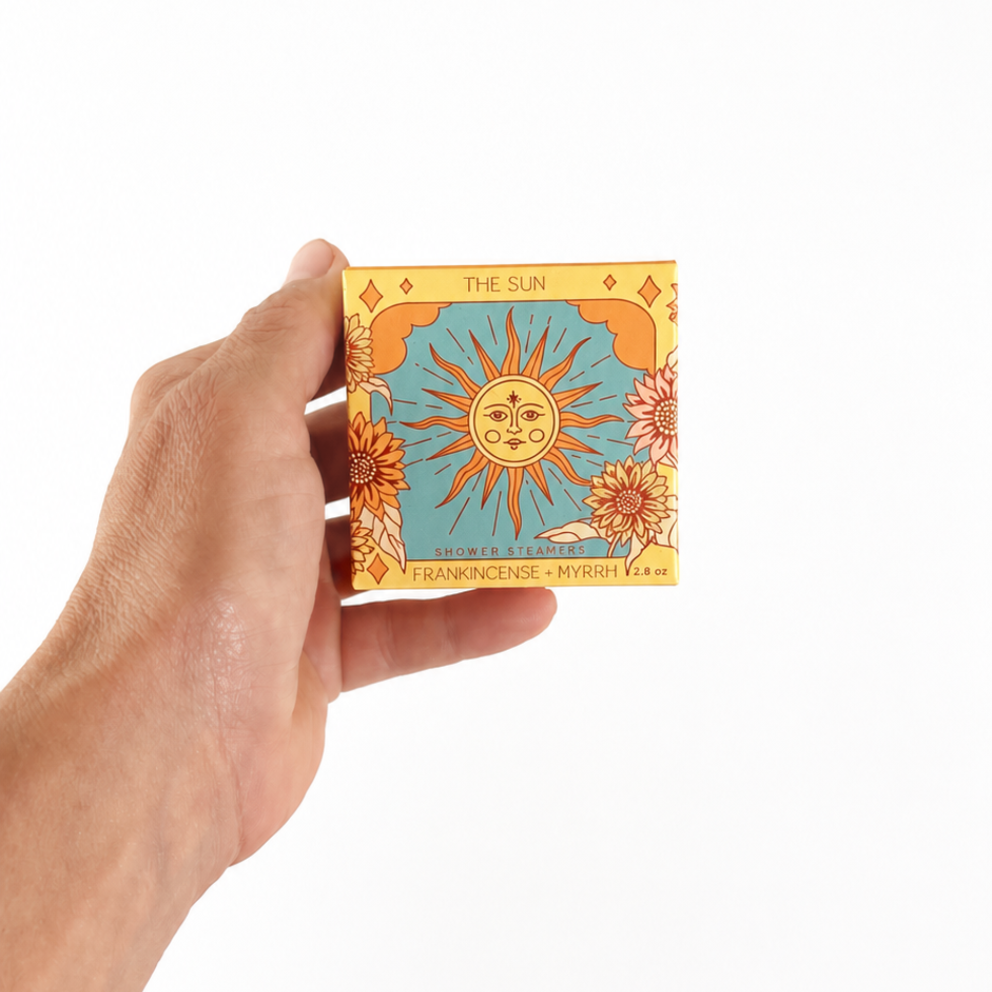 Hand holding The Sun Shower Steamer Set in Frankincense & Myrrh by Sow the Magic® to show the size of the botanical aromatherapy gift set.