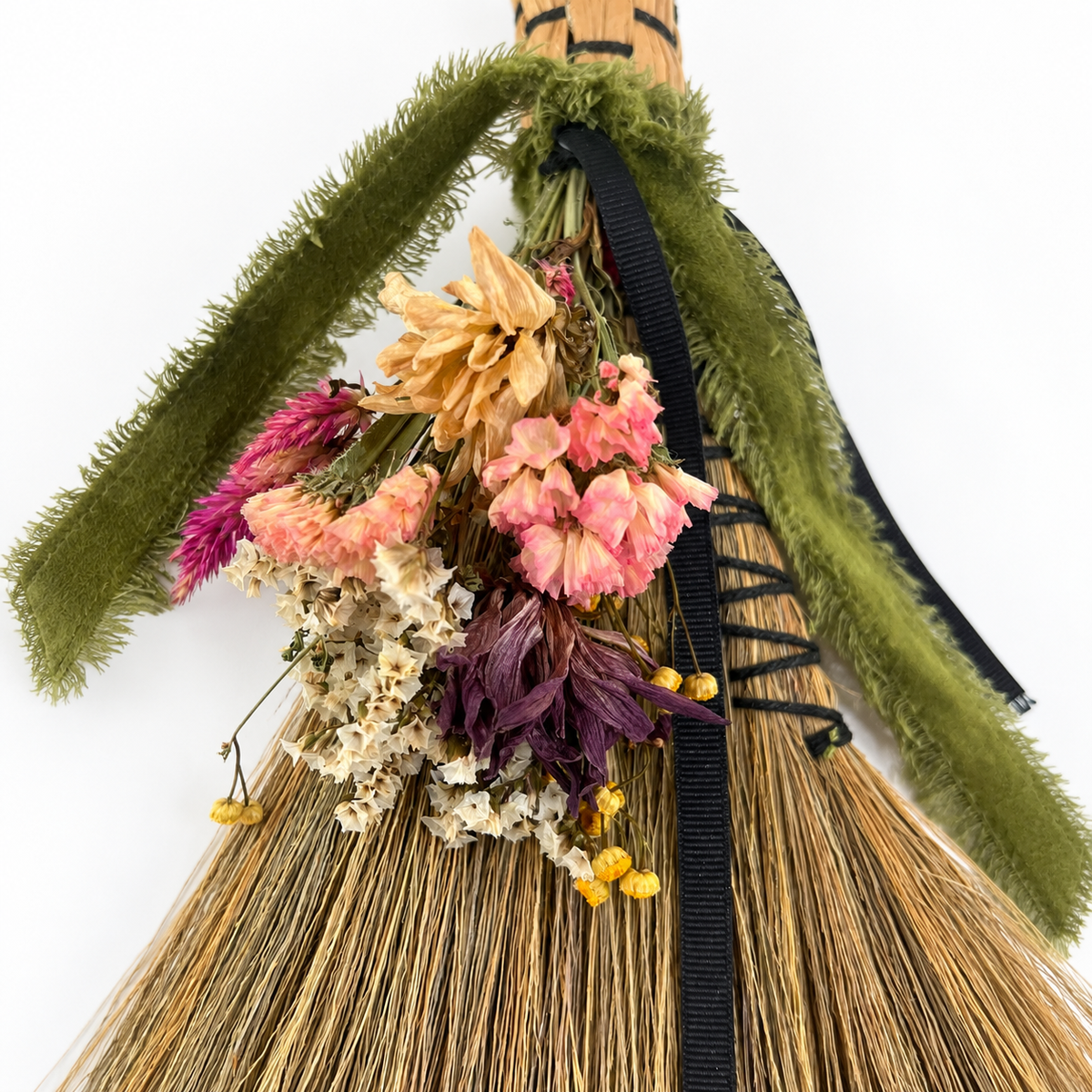 Close-up of farm-grown pink, cream, purple and golden dried botanicals arranged on The Woodland Keeper’s Botanical Broom.