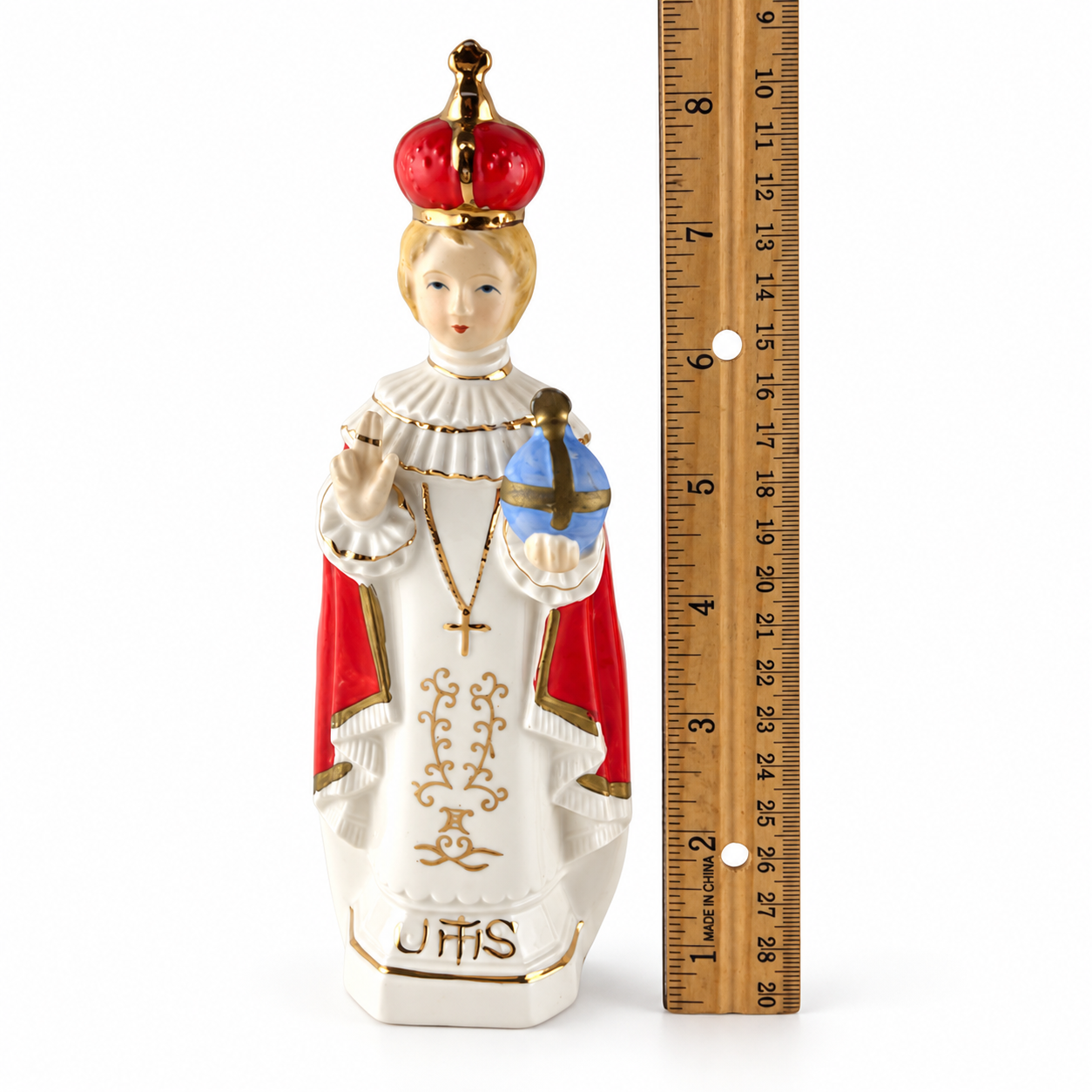 Vintage Infant of Prague porcelain figurine shown beside a ruler for size and scale reference