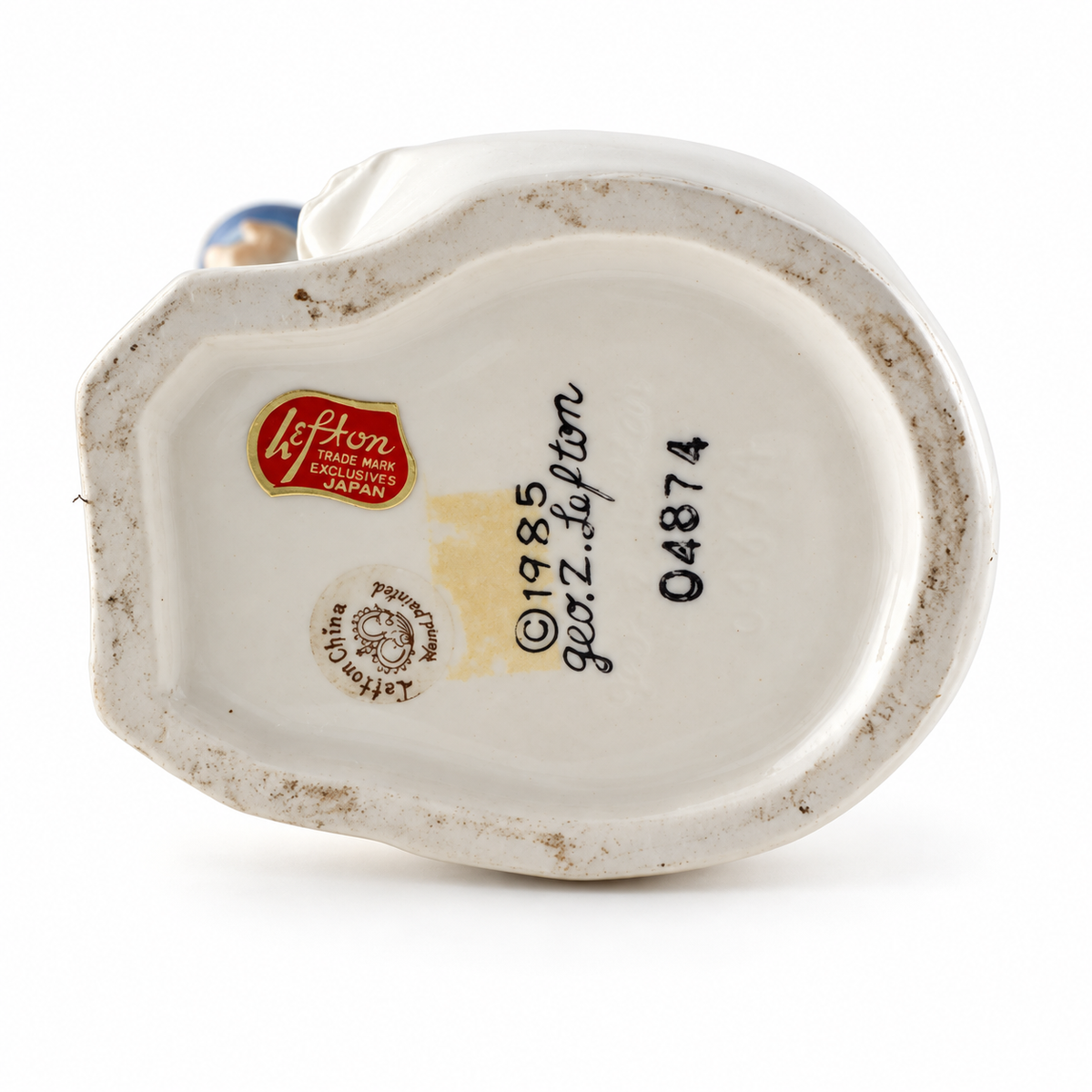 Bottom of vintage Infant of Prague porcelain figurine showing original Lefton China maker label and identifying marks
