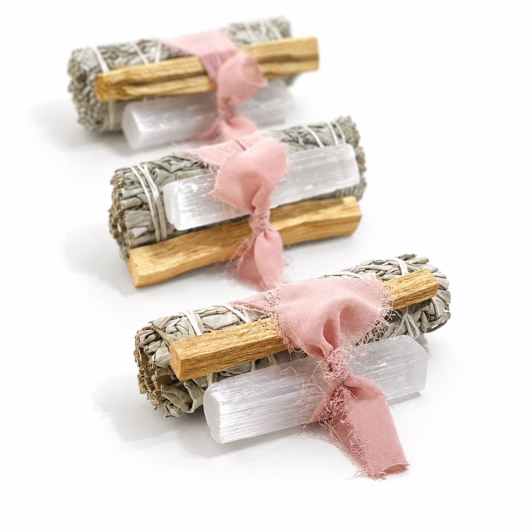 Three handcrafted White Sage Protection Ritual Bundles featuring White Sage, Palo Santo, a genuine Selenite cleansing wand and soft blush ribbon, arranged on a bright white background. Handmade spiritual gift sets by Sow the Magic®.