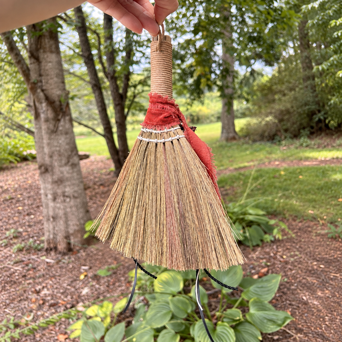 Back view of the handmade Wildheart Botanical Broom showing natural broomcorn, rust fabric ribbon and hanging loop
