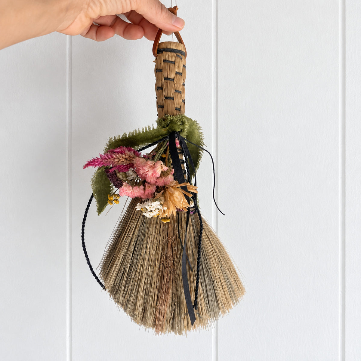 Hand holding the Wildheart Botanical Broom to show its size and proportions