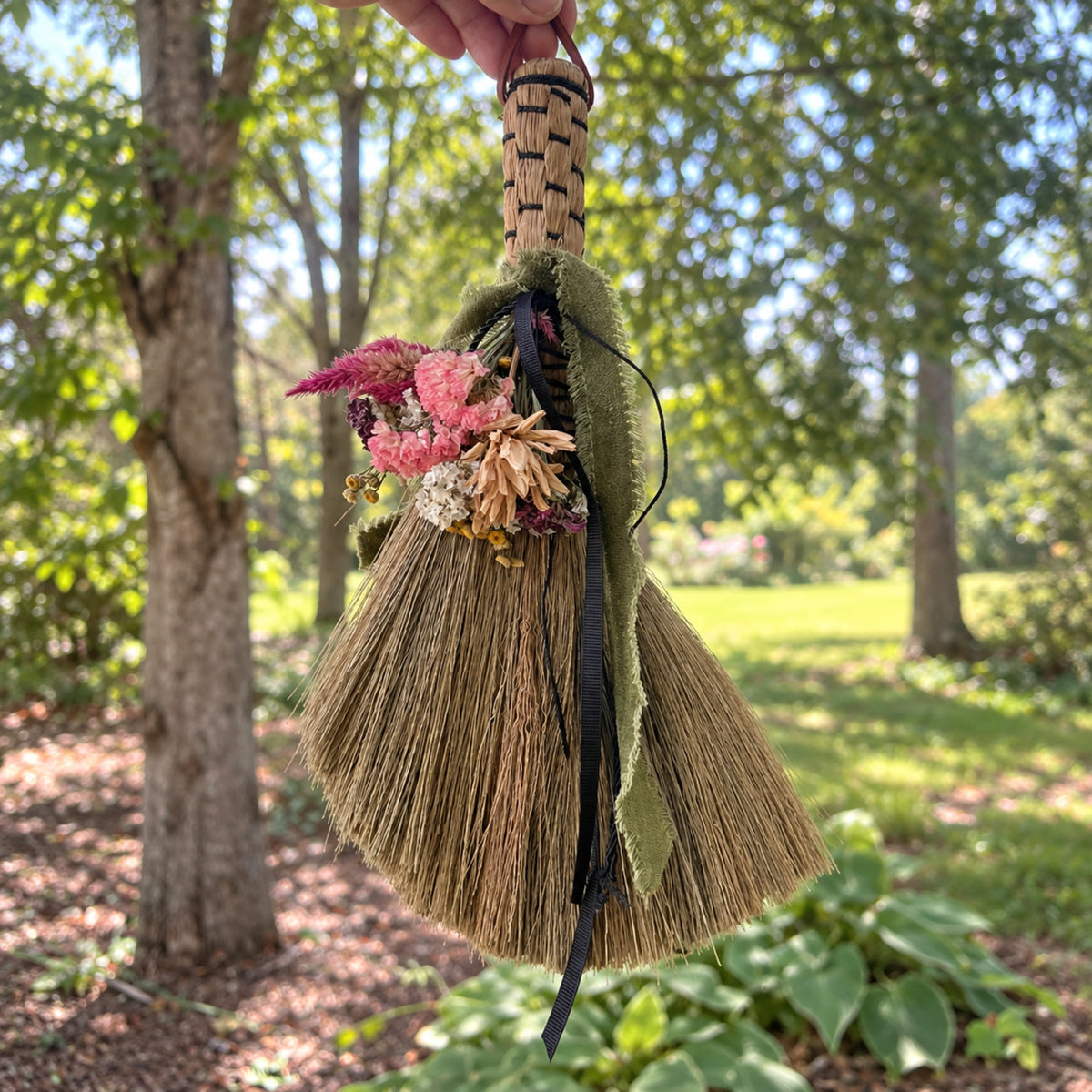 Wildheart Botanical Broom hanging outdoors among trees and greenery