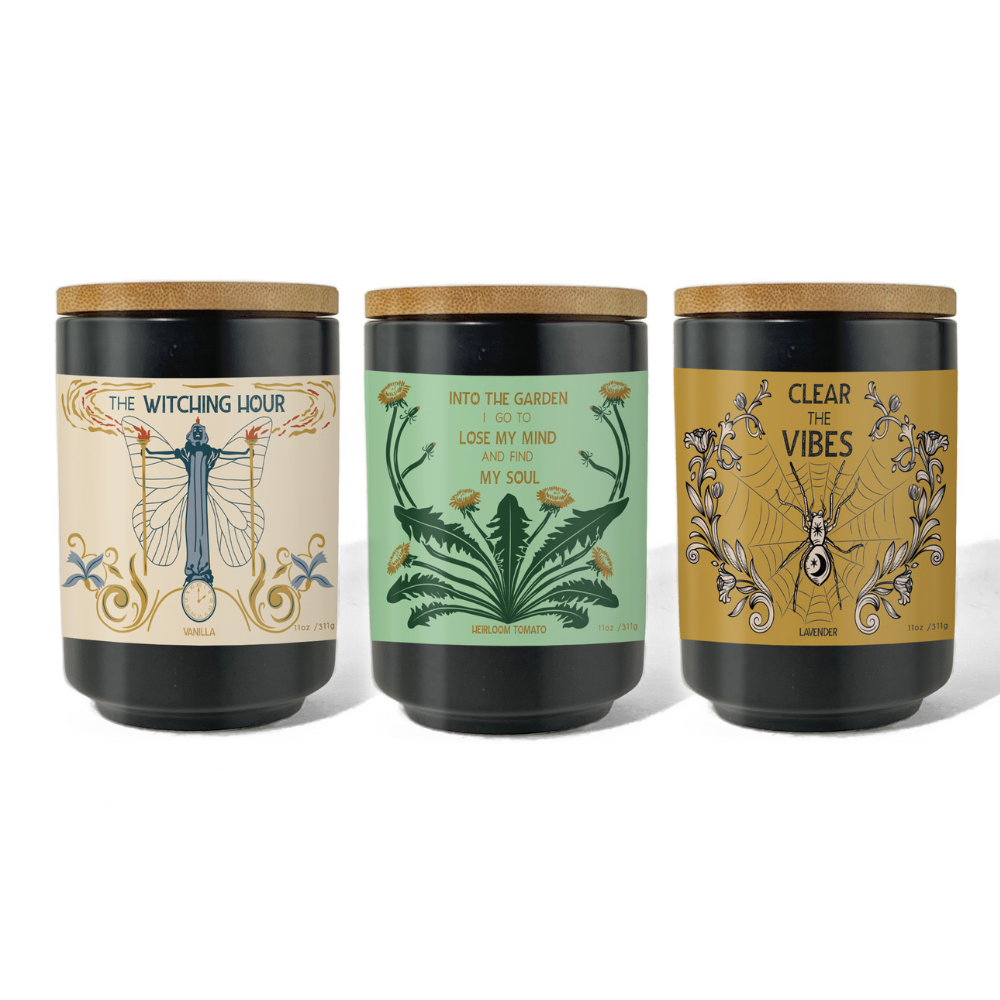 Three dark glass candles with gold botanical labels, witchy candle collection