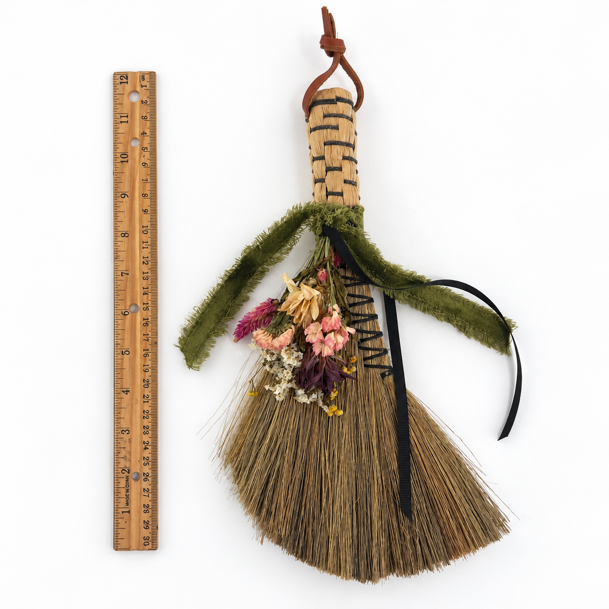 The Woodland Keeper’s Botanical Broom displayed beside a ruler to show its handcrafted size and proportions.