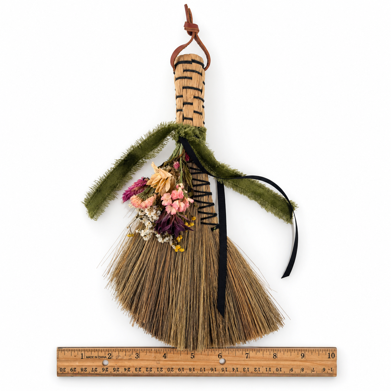 Full-length view of The Woodland Keeper’s Botanical Broom displayed upright with dried flowers, velvet ribbon and a leather hanging loop.