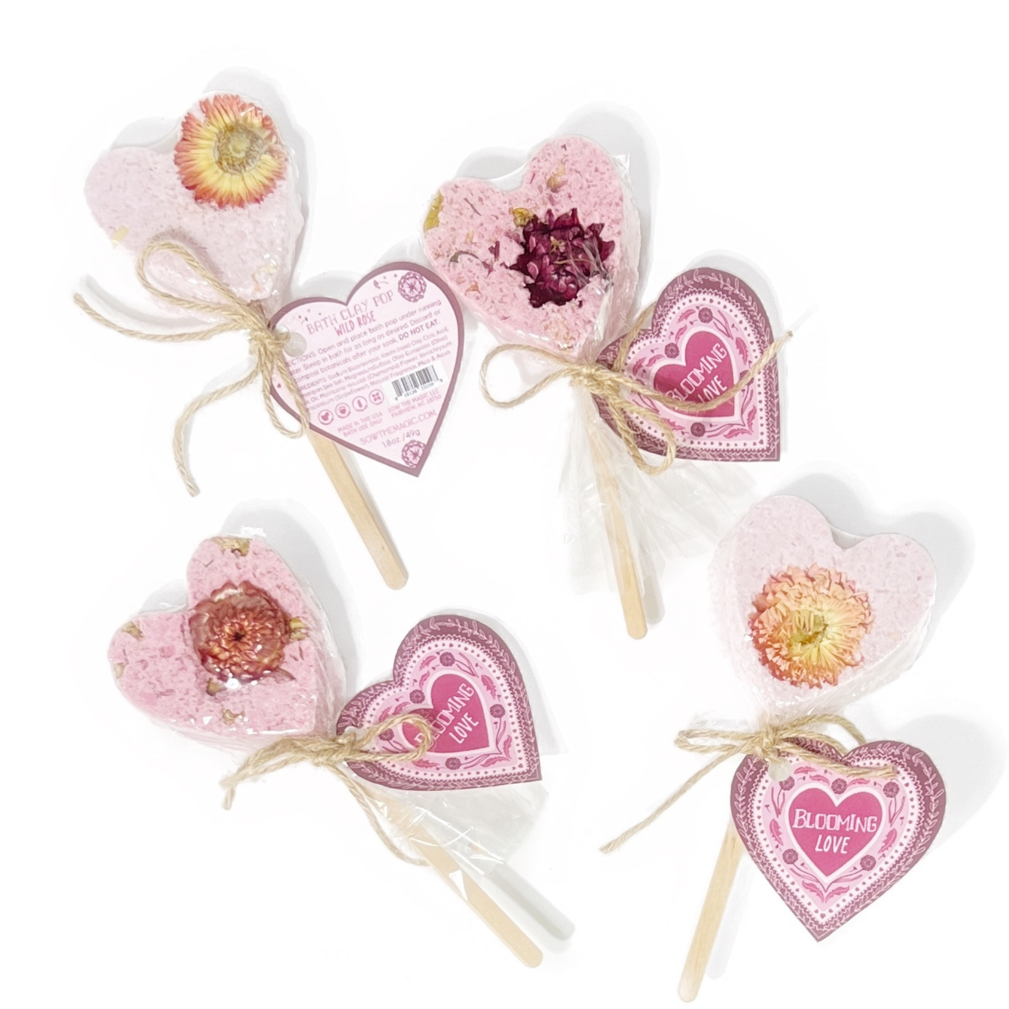 Set of pink heart bath clay pops with natural dried flowers and “Blooming Love” heart tags, perfect for gifting.