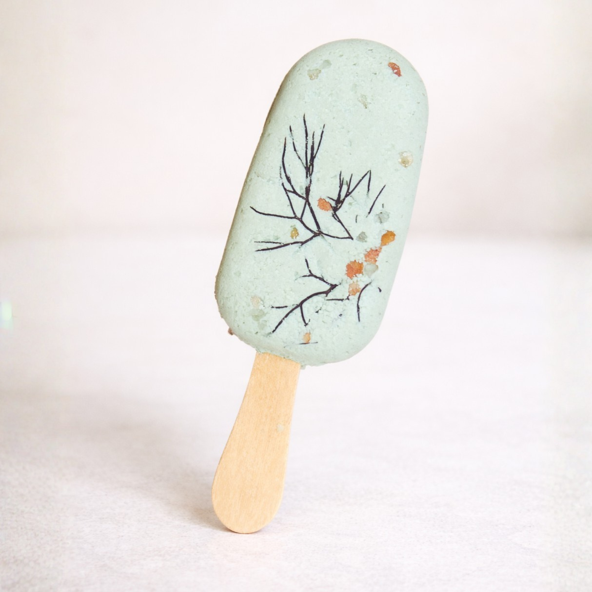 Handmade green Bath Clay Pop styled on soft neutral backdrop