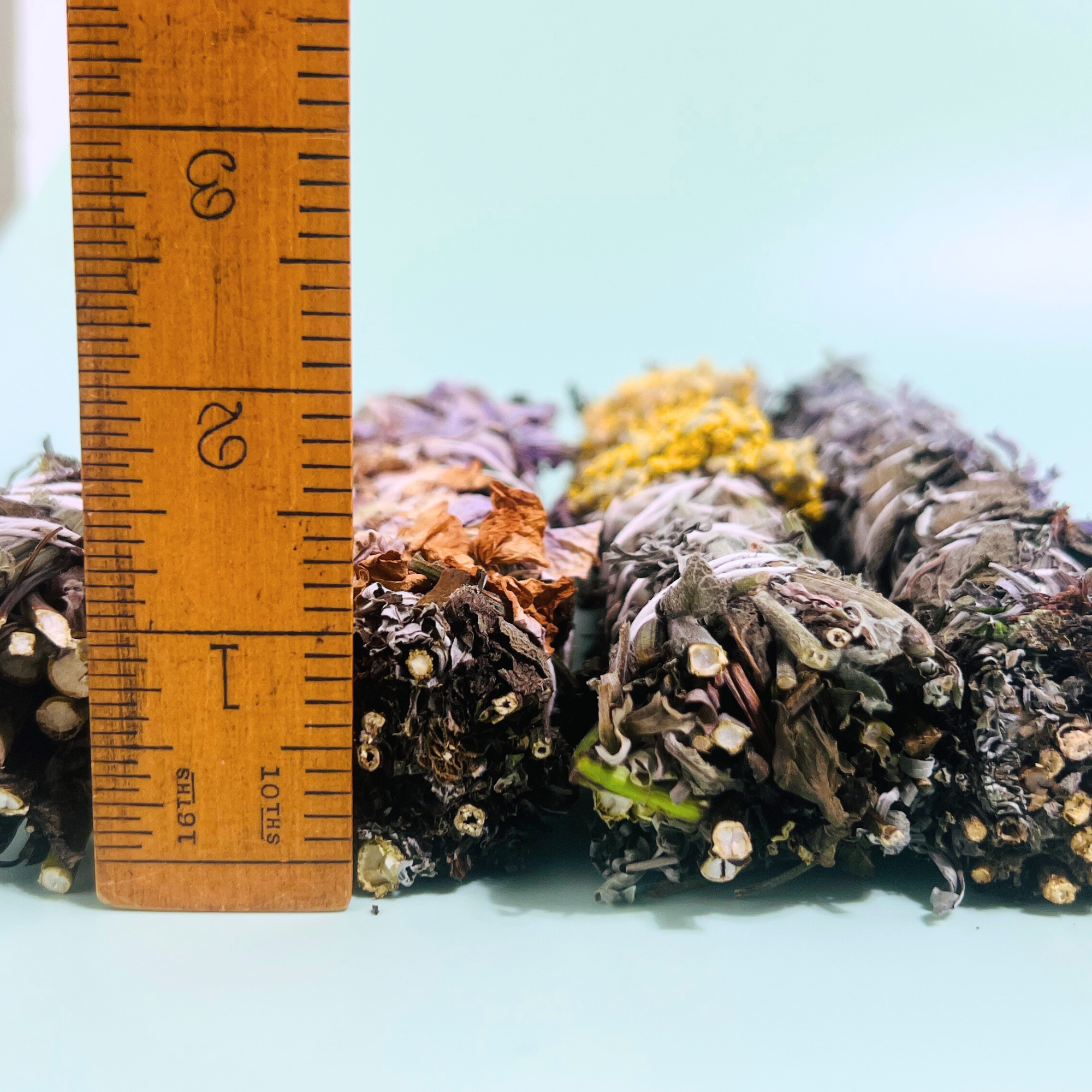 Botanical herbal wafting wand shown beside a ruler to demonstrate its handmade size and thickness