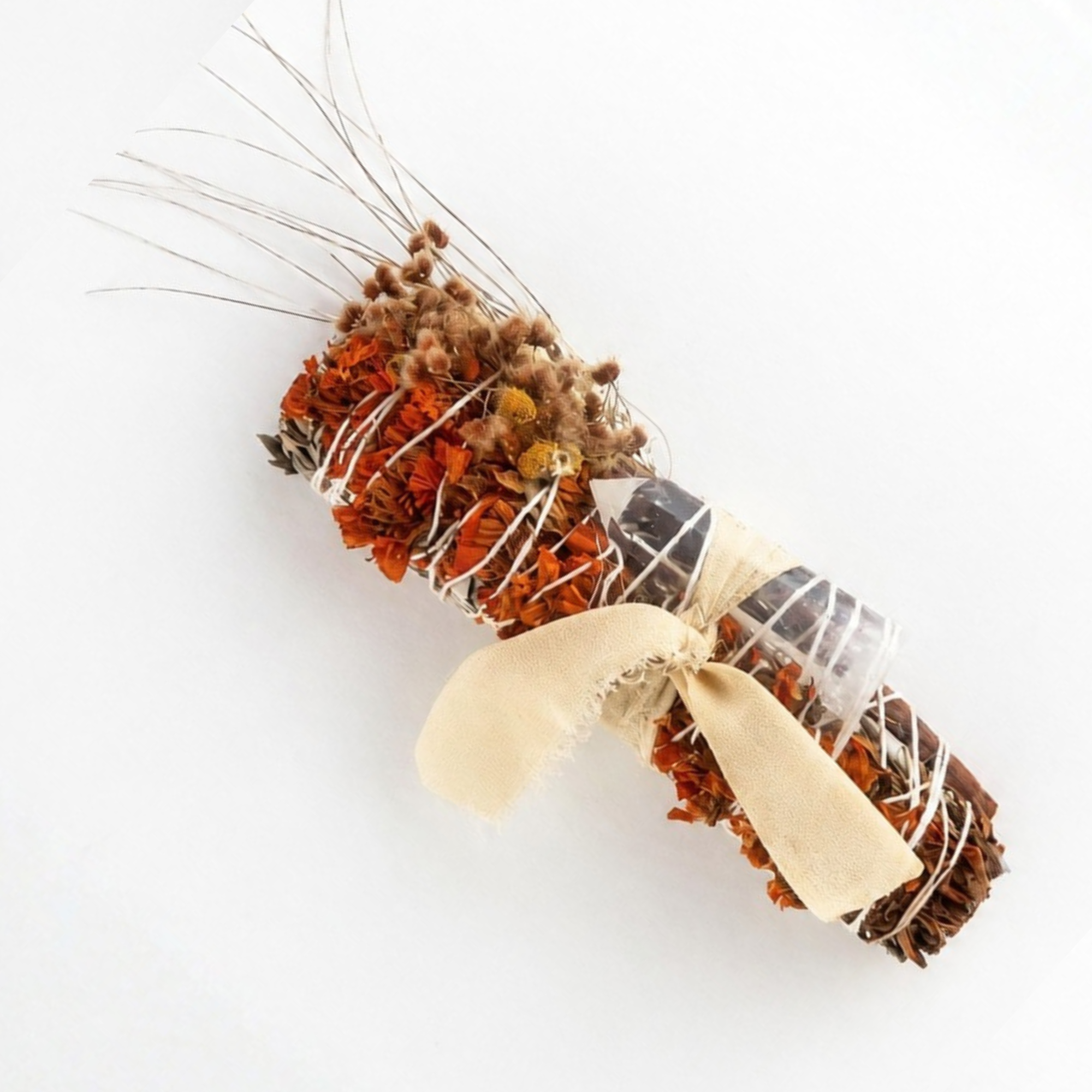 Close-up of a botanical smoke cleansing wand handcrafted with dried flowers, herbs, grasses and natural twine