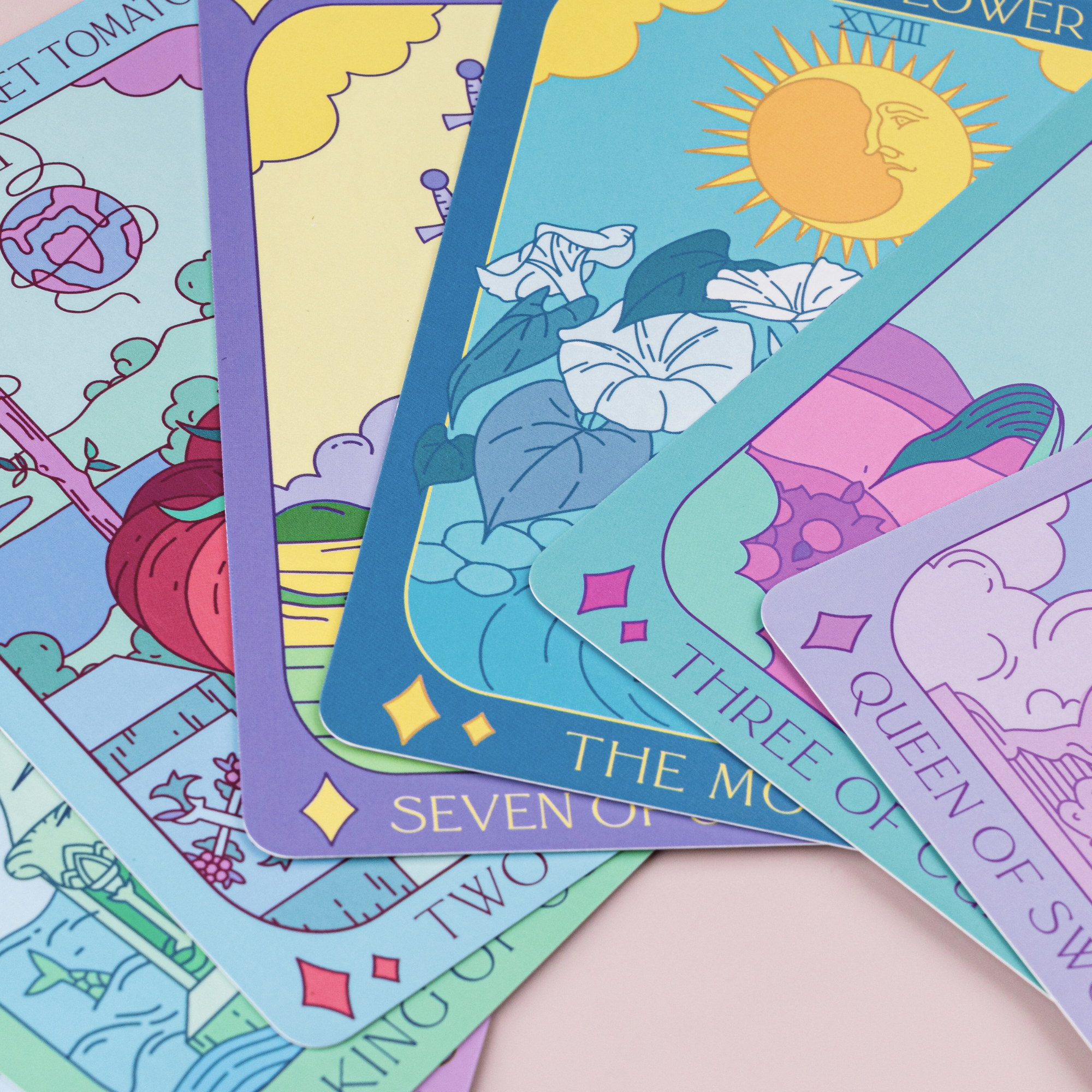 Close-up of Botanical Tarot cards highlighting Moonflower and King of Cups illustrations with bright pastel colors.