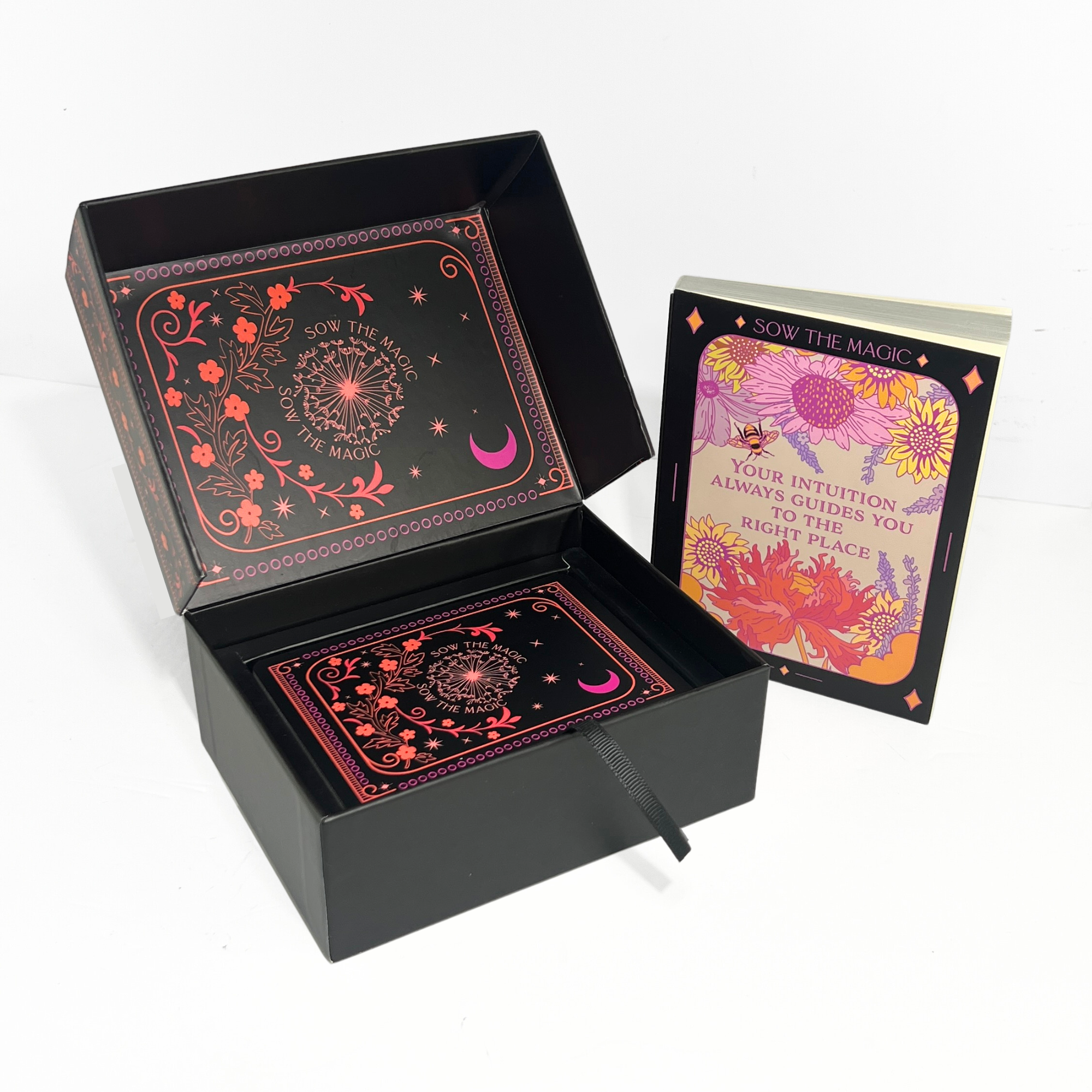 Open Botanical Tarot Deck box revealing card back design with celestial patterns and companion guidebook beside it.