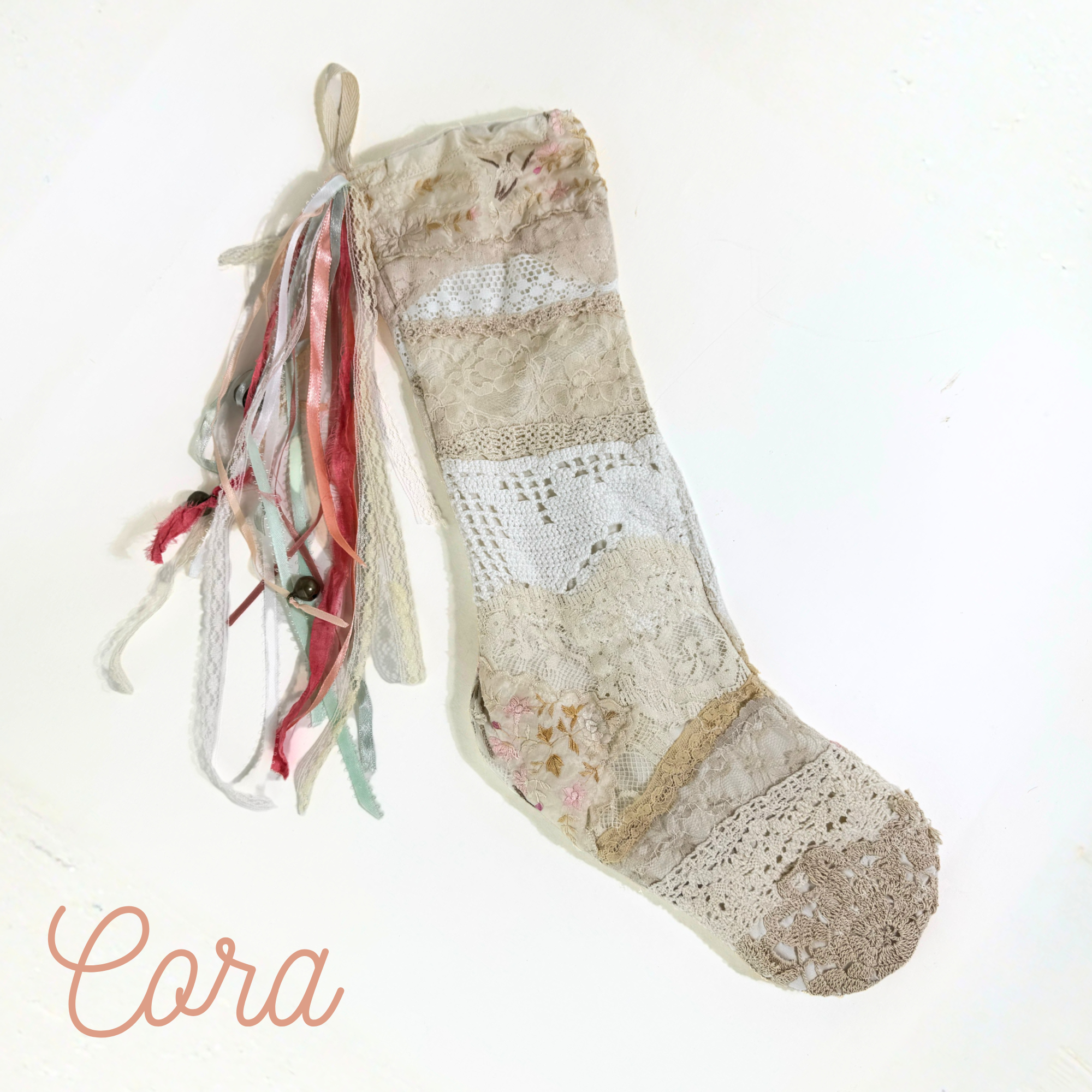Handmade lace Christmas stocking with pastel ribbon tassels, vintage-inspired patchwork holiday decor