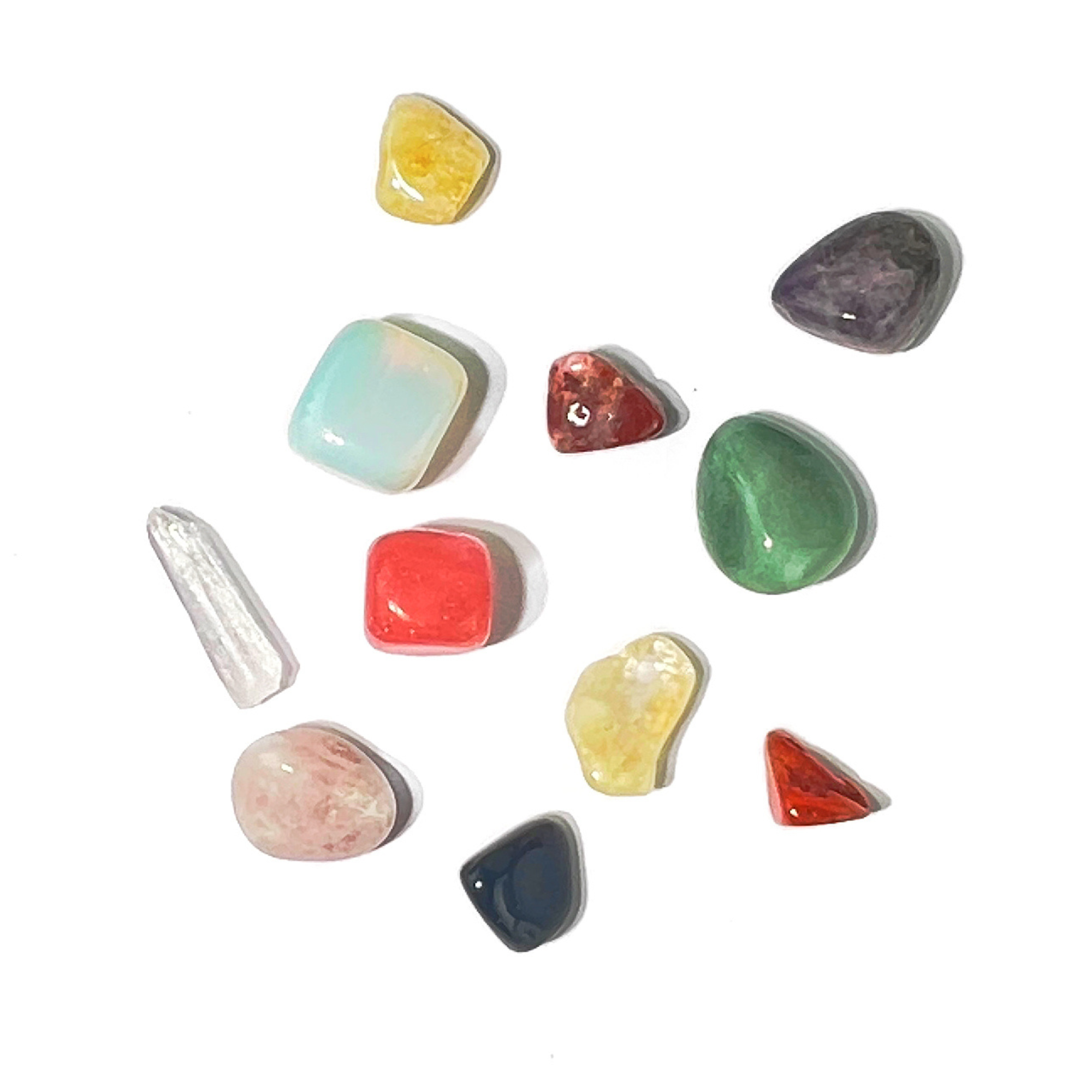 Nine assorted tumbled gemstones displayed beside open crystal gift set