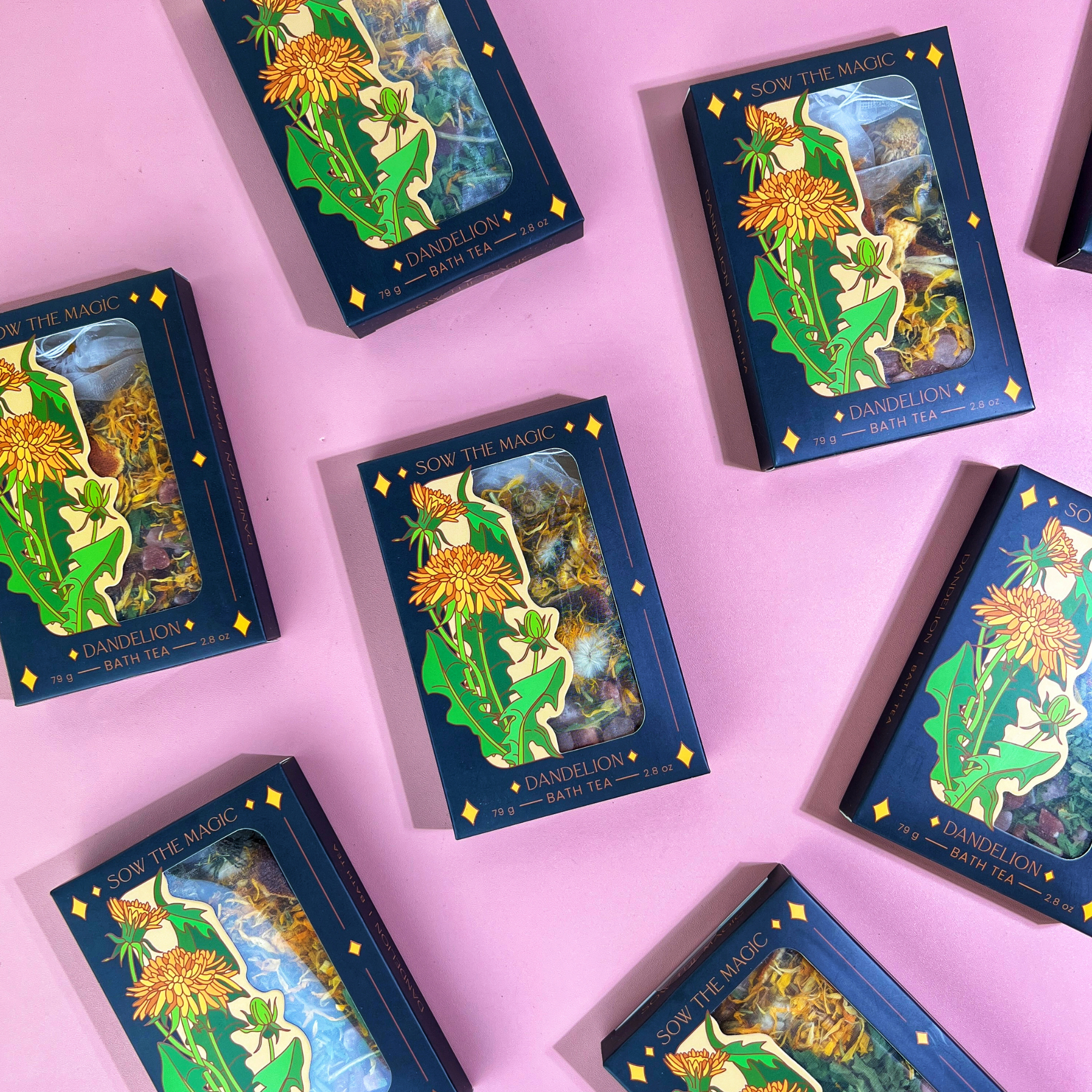 Sow the Magic Dandelion Tarot Botanical Bath Tea Boxes on pink background, featuring floral packaging with golden yellow dandelion design.