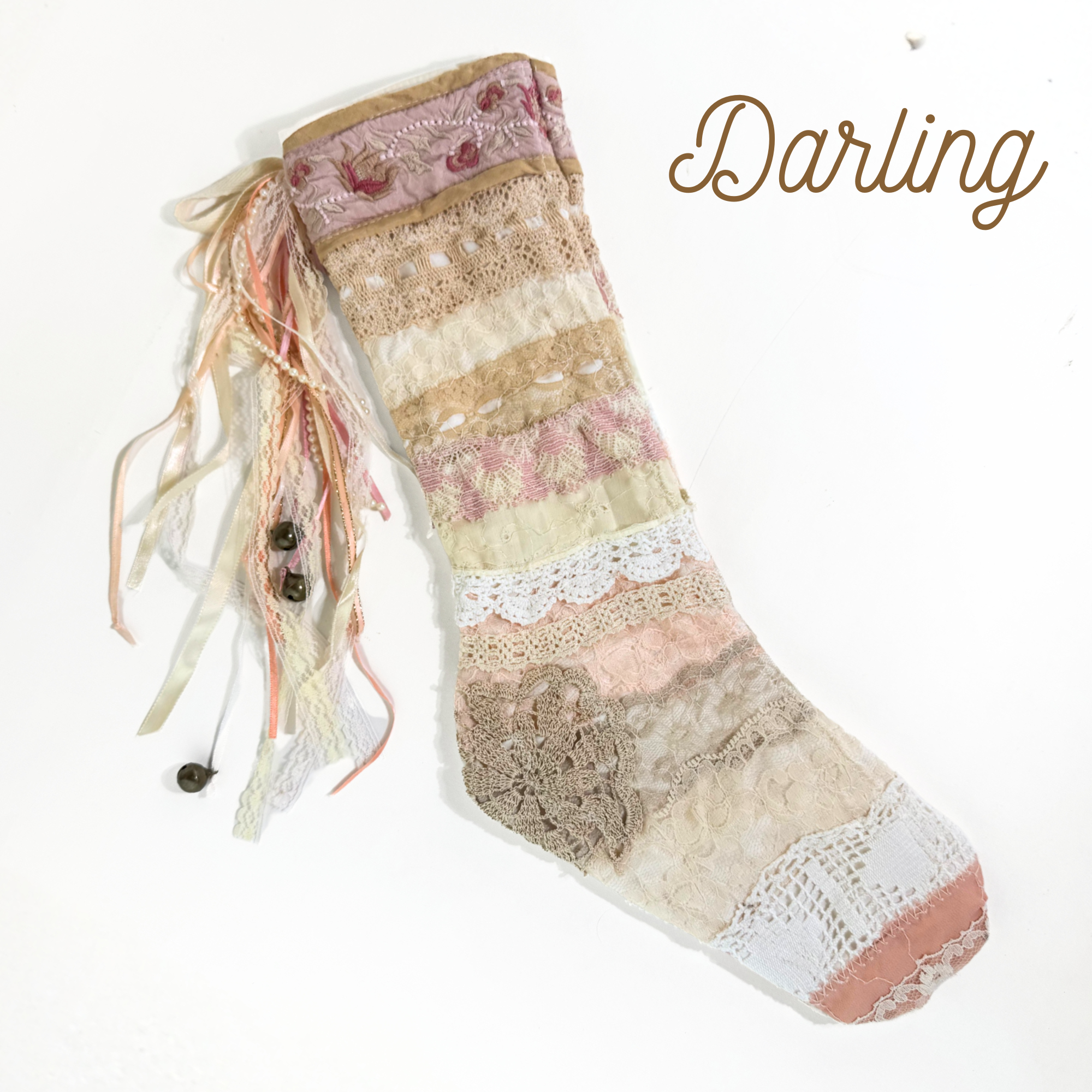 Handmade lace Christmas stocking with peach, ivory, and blush lace patchwork and ribbon tassels