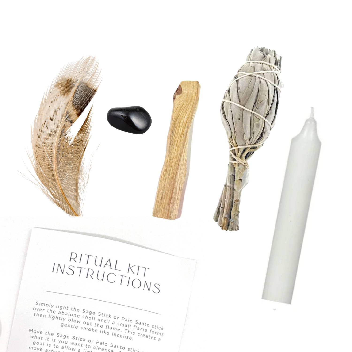 Flat lay of Empowering Ritual Kit items including feather, Sage, Palo Santo, Obsidian, candle and instructions