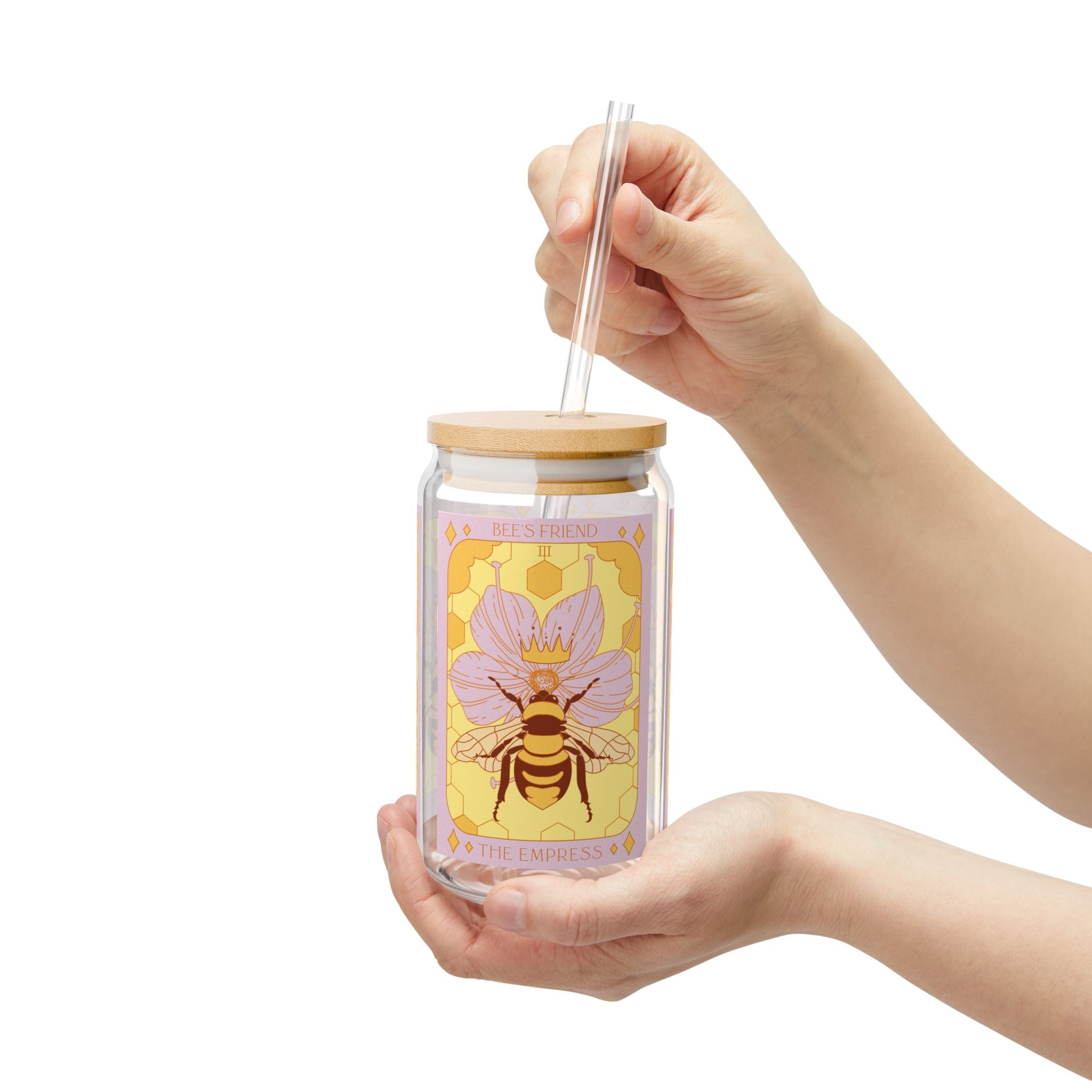 Hand holding Empress Bee tarot glass tumbler with botanical bee illustration, bamboo lid and clear straw