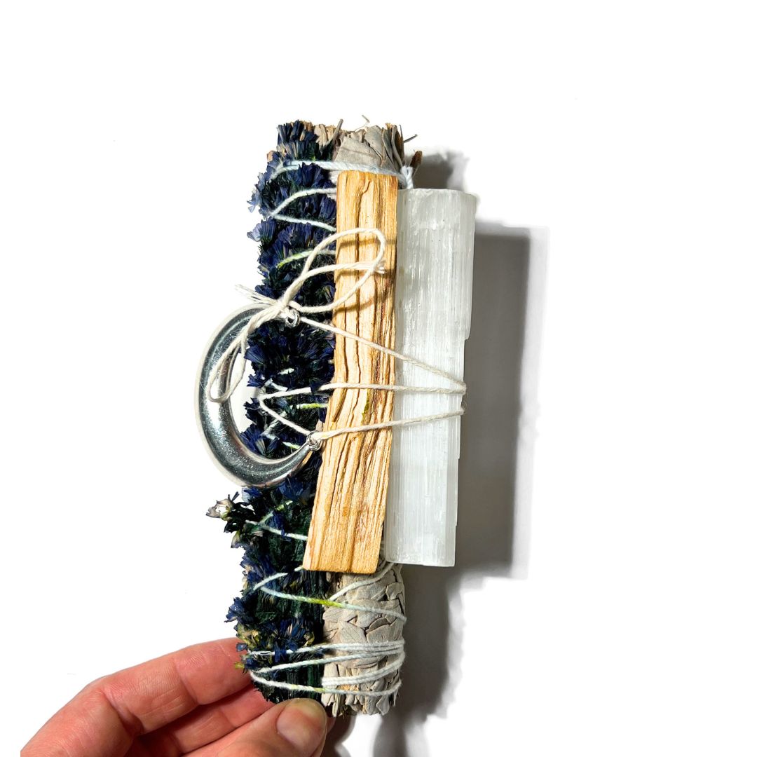 Side view of the Goodnight Moon Ritual Set showing the sage bundle, palo santo stick, selenite and moon charm.