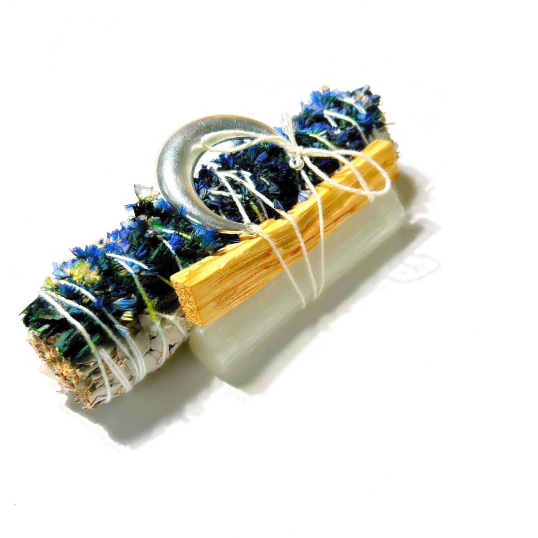 Detailed view of the Goodnight Moon sage bundle decorated with blue sinuata flowers, selenite, palo santo and a silver moon charm.