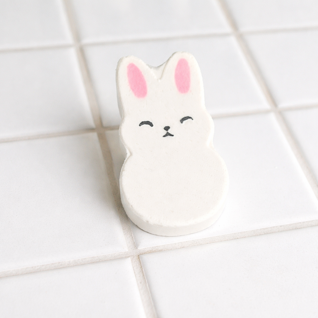 Handmade bunny bath bomb with packaging in bright spa inspired bathroom scene