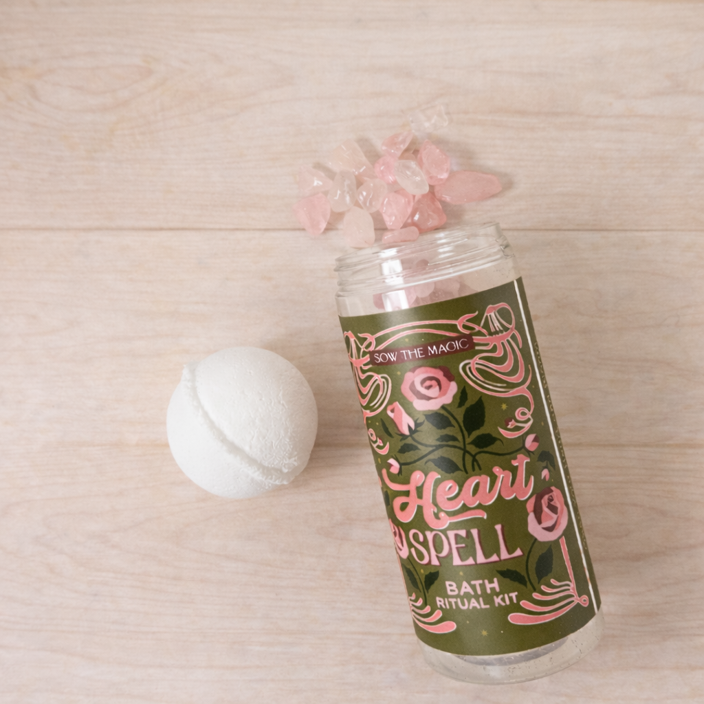 Heart Spell Bath Ritual Kit jar with rose quartz gemstones styled on a pale wood background