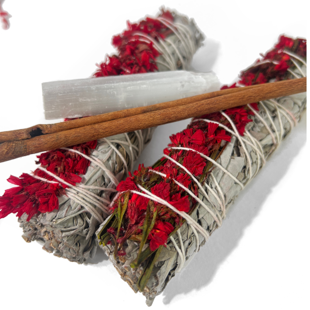 Close-up of red sinuata and white sage smudge bundle tied with red and white twine