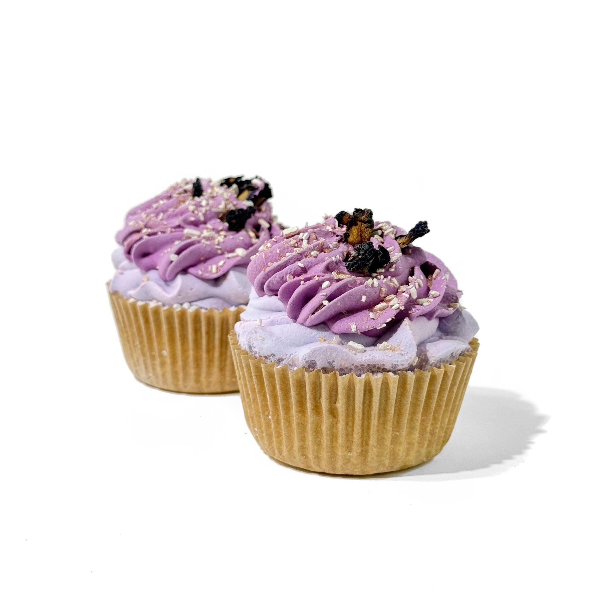 Close-up of two Lavender Mint Cupcake Bath Bombs with swirled lavender icing and floral toppings