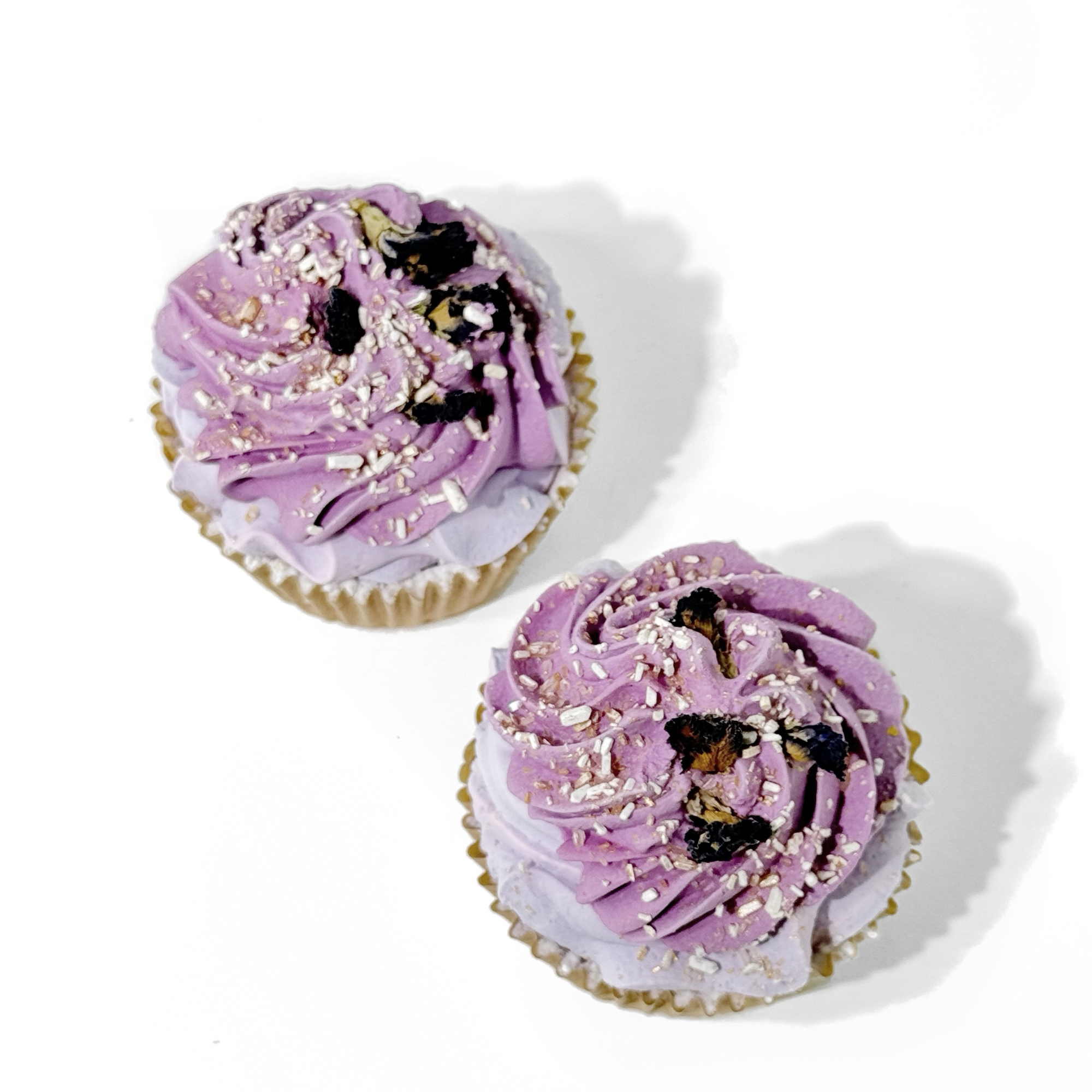 Two Lavender Mint Cupcake Bath Bombs topped with purple frosting, dried lavender, and pearl sprinkles