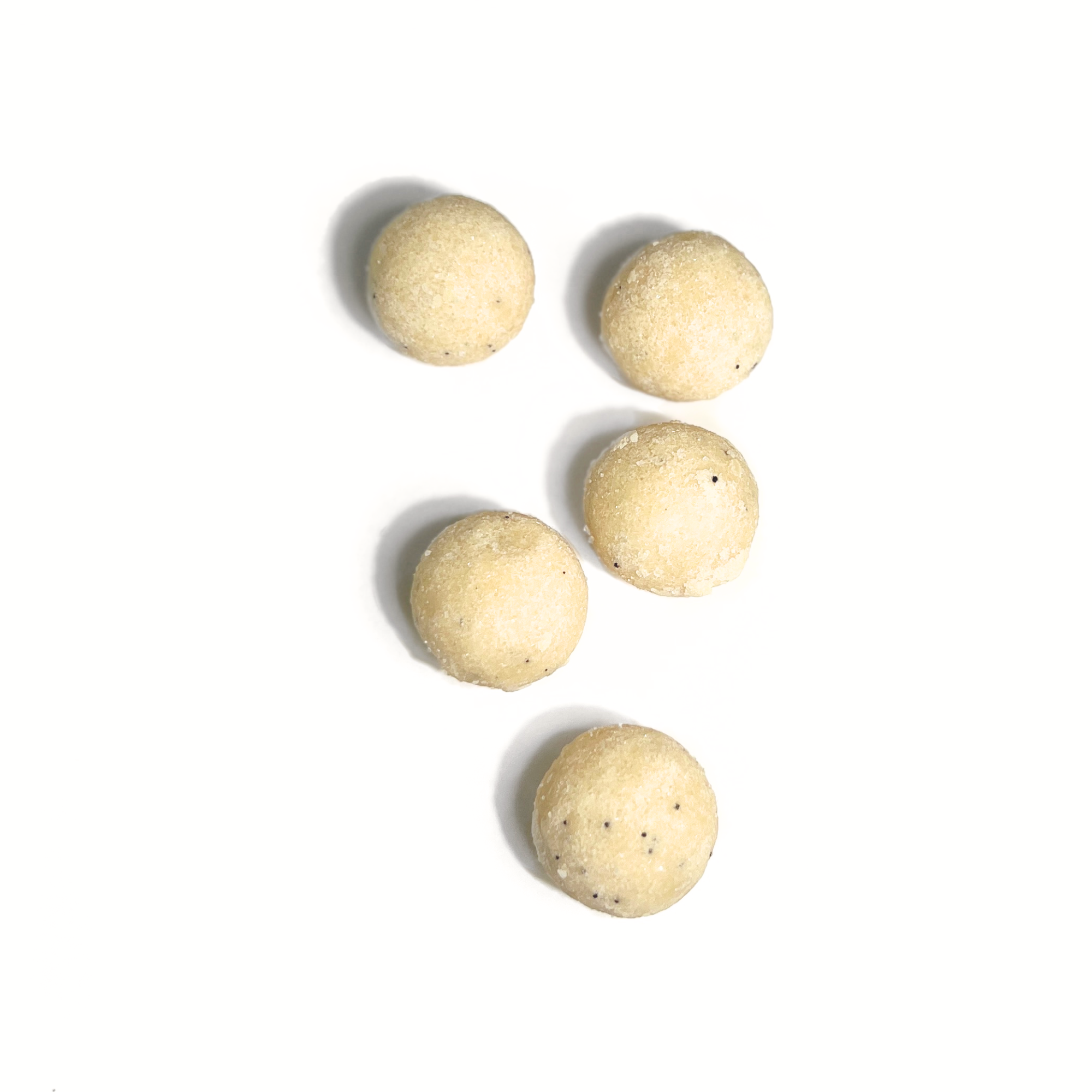 Flat lay of Lemon Zest sugar scrub balls spilling from jar