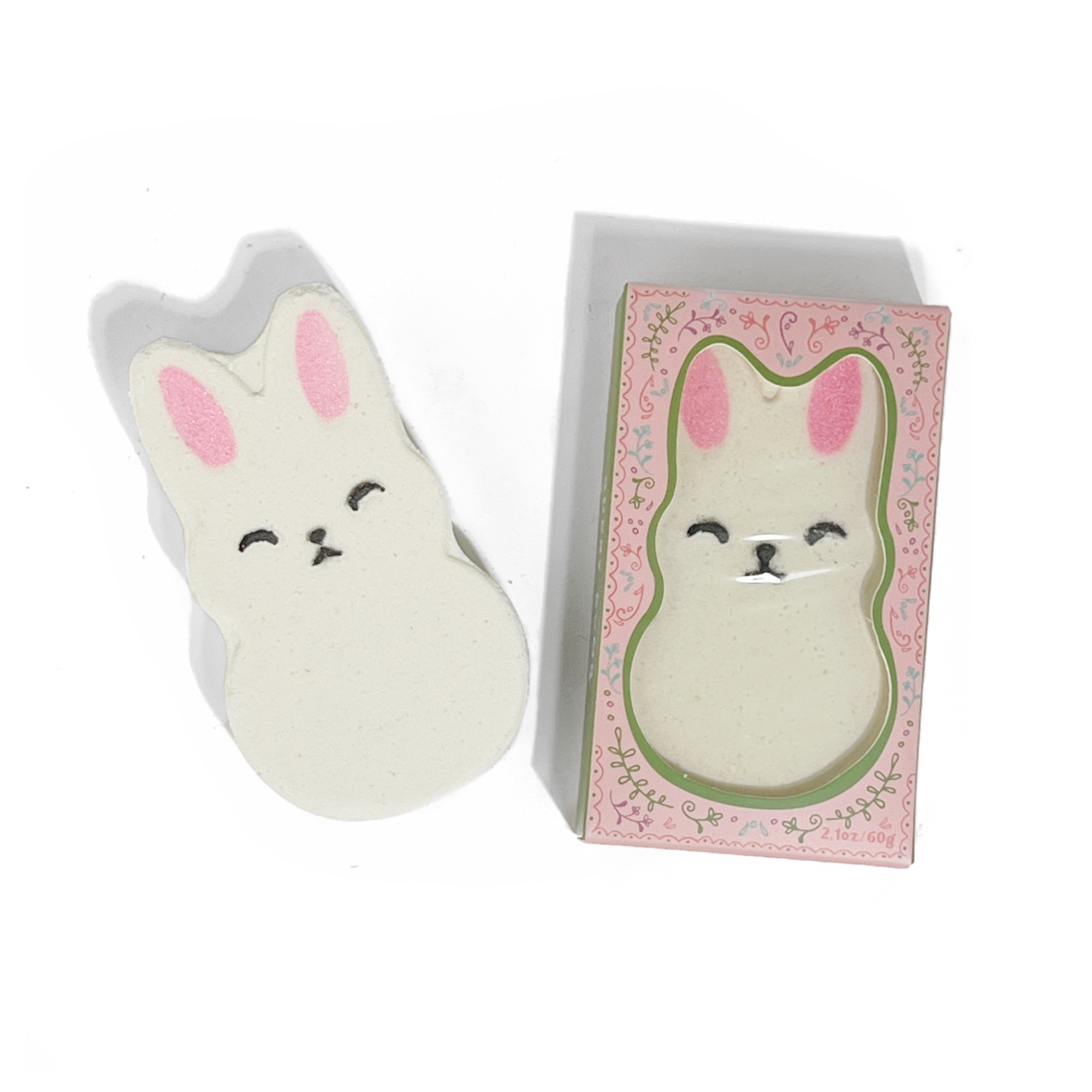 Bunny-shaped strawberry bath bomb with shea butter beside pink floral box