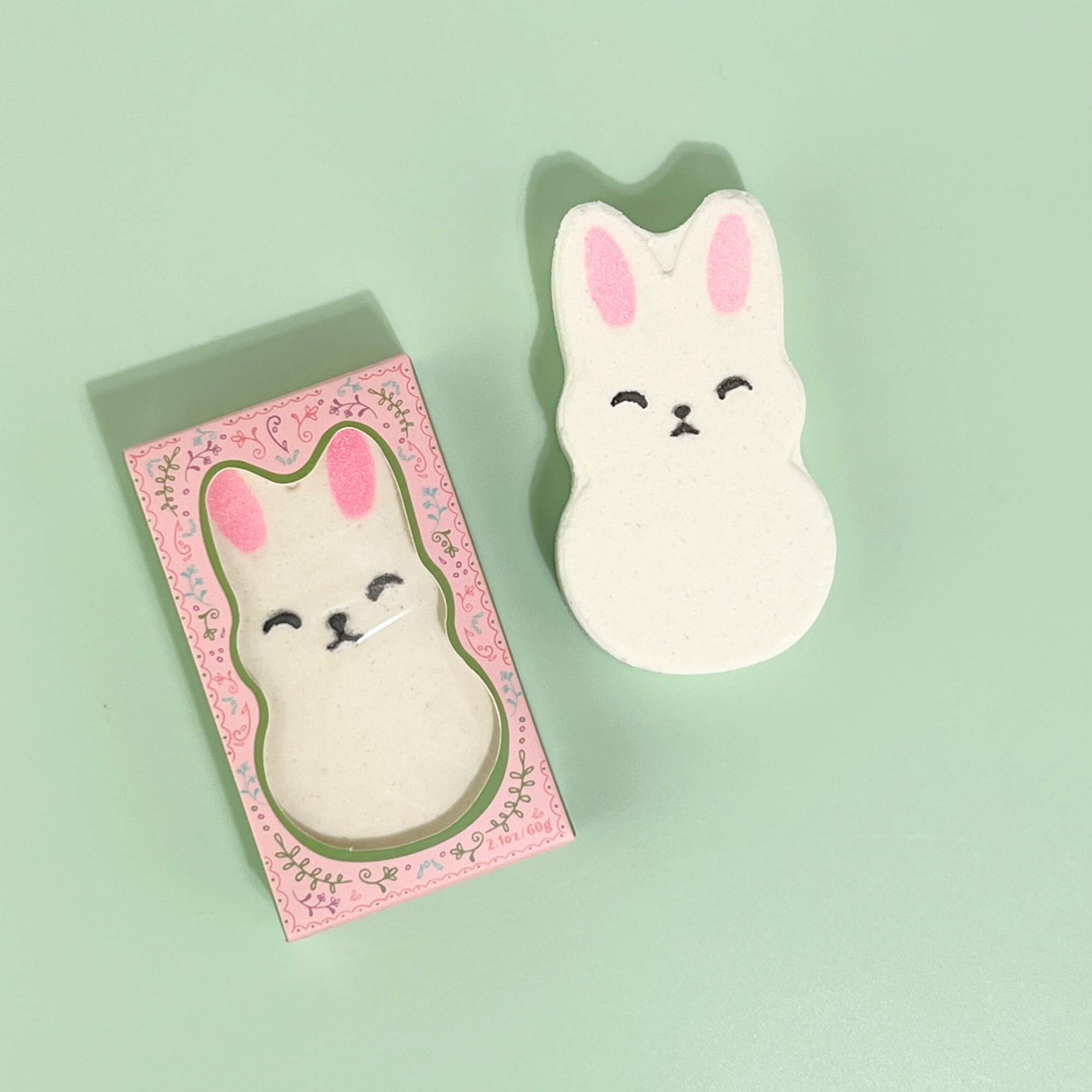 Bunny-shaped bath bomb and matching pink box with green accents
