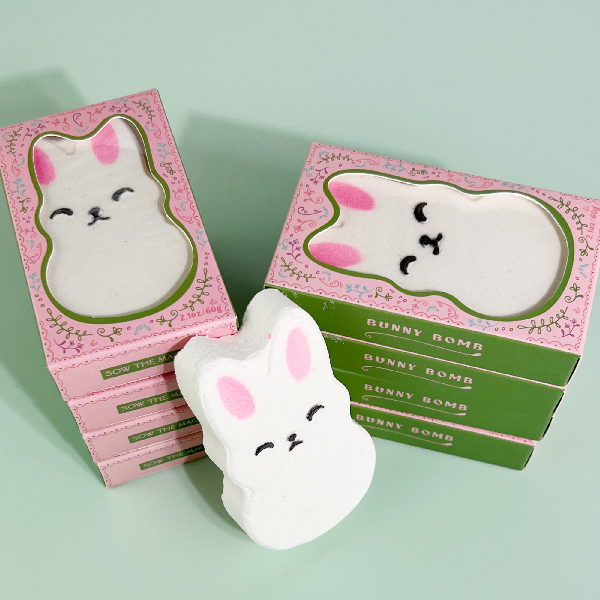 Bunny bath bombs and boxes arranged on green background for Easter display