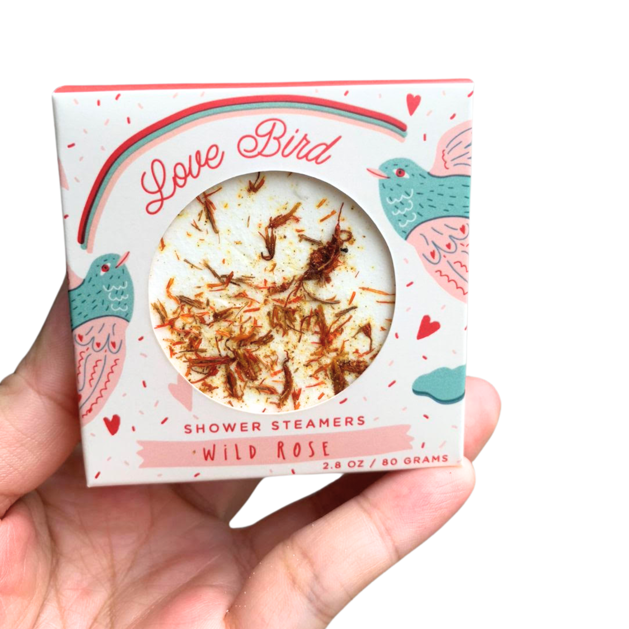 Hand holding Love Bird wild rose shower steamer in illustrated pink and teal packaging