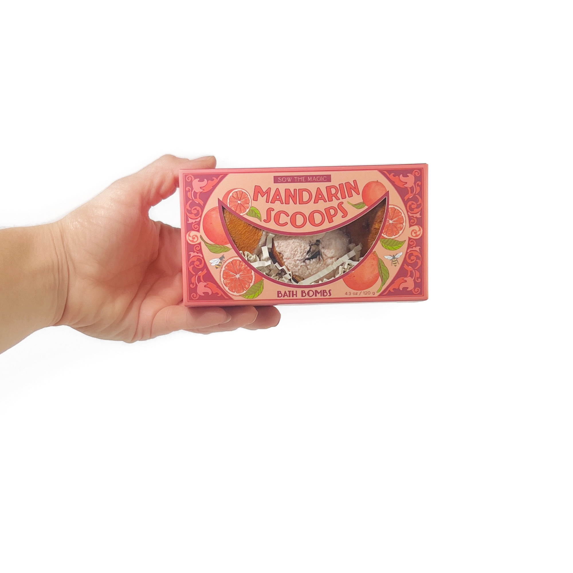 Hand holding Mandarin Scoops Bath Bomb Gift Set showing compact size and illustrated orange box design